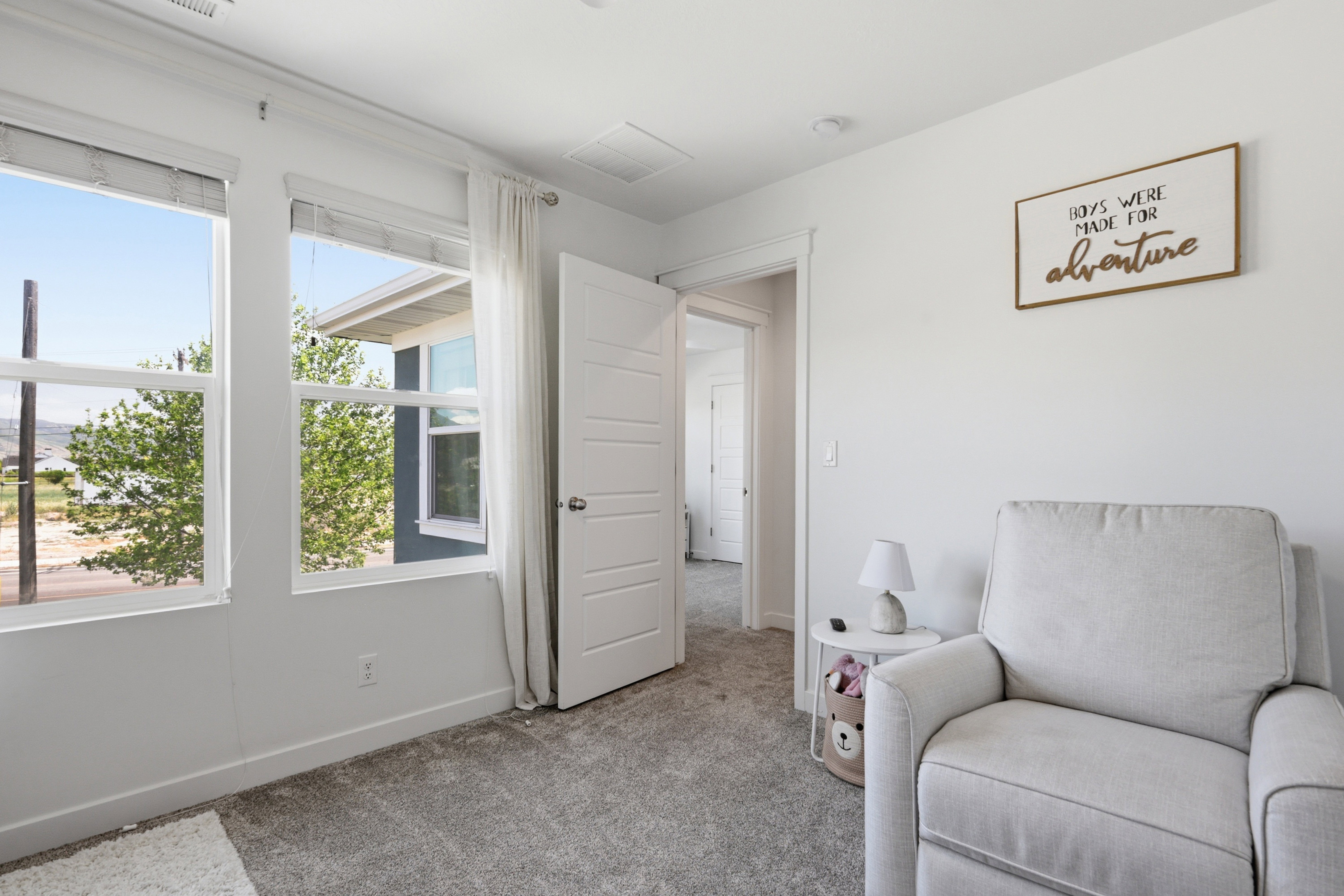 Light-filled interior space with two large windows, offering exterior views of mature trees and distant landscape