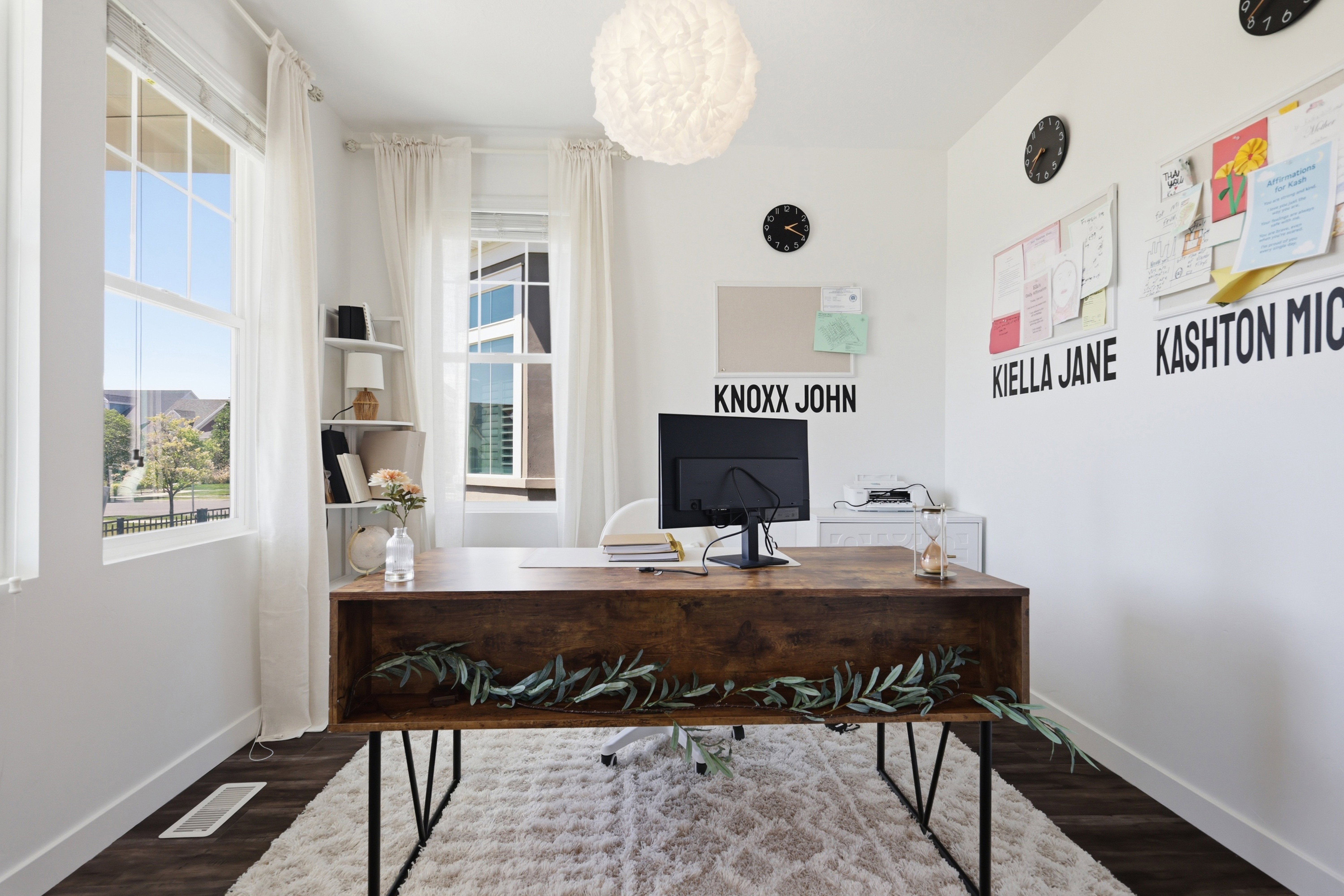 Dedicated workspace featuring dark wood-finish flooring, white walls, and a contemporary light fixture