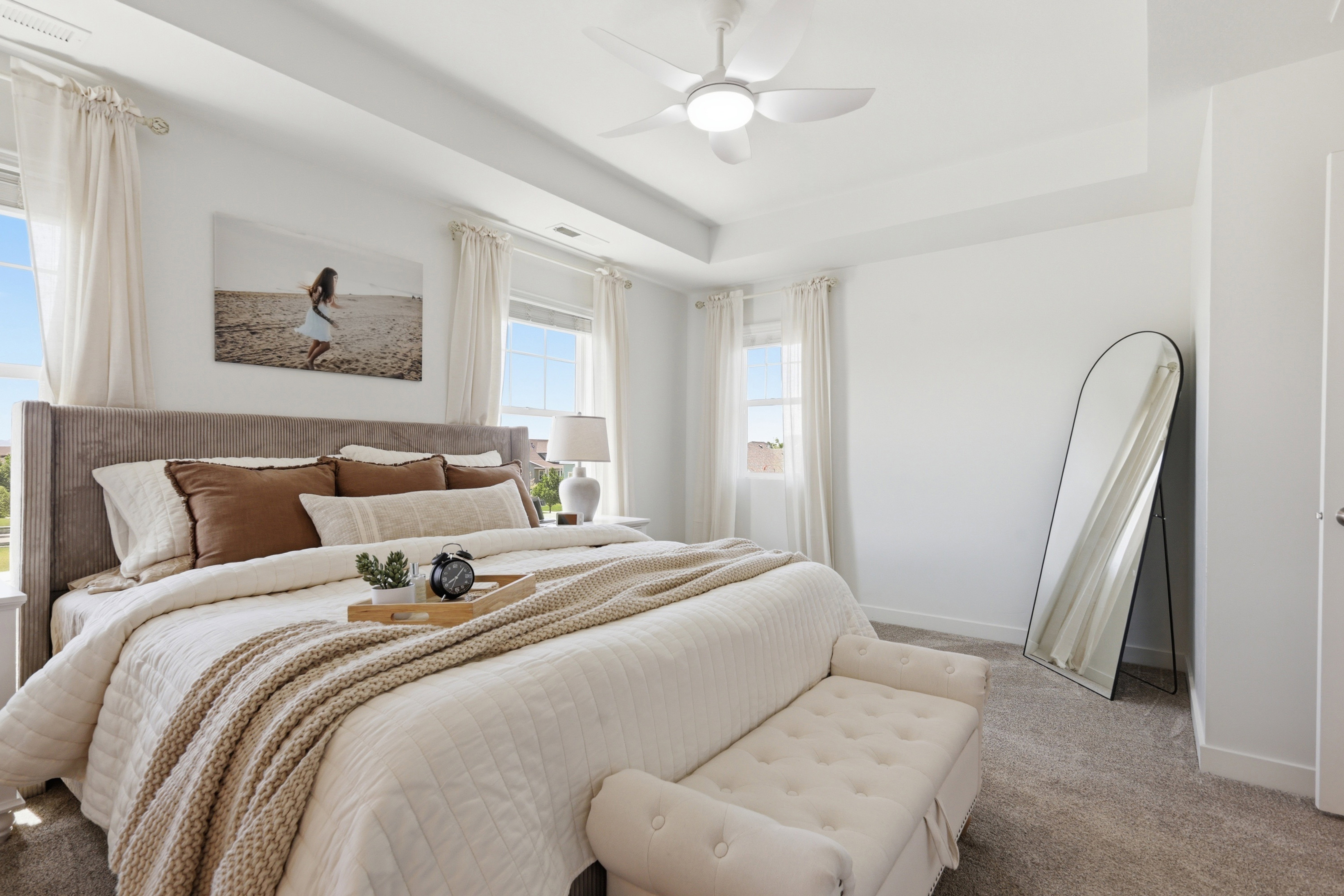 Spacious room featuring a tray ceiling, ceiling fan with integrated lighting, and carpet flooring