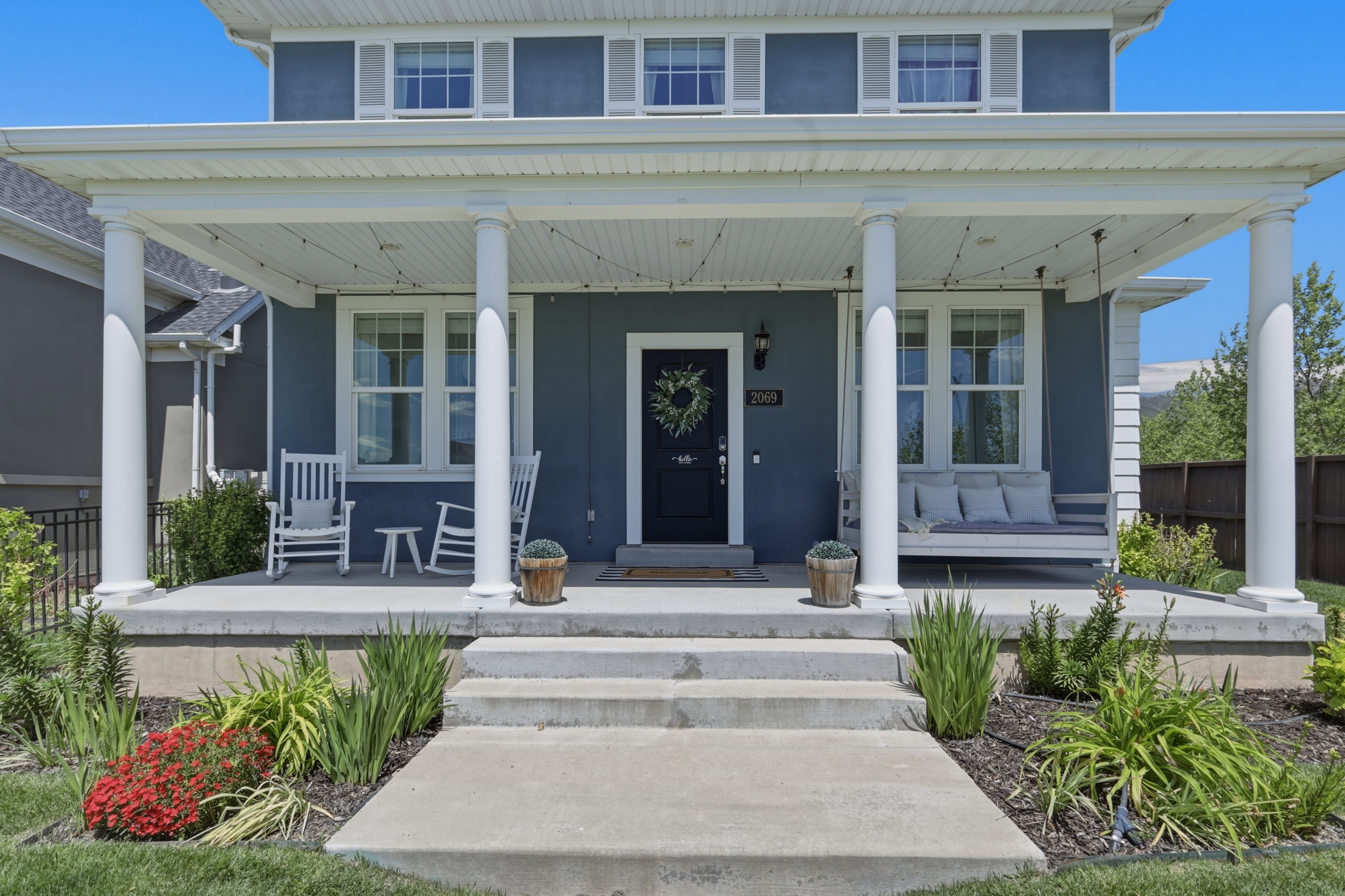 Charming blue exterior featuring white trim and a covered front porch