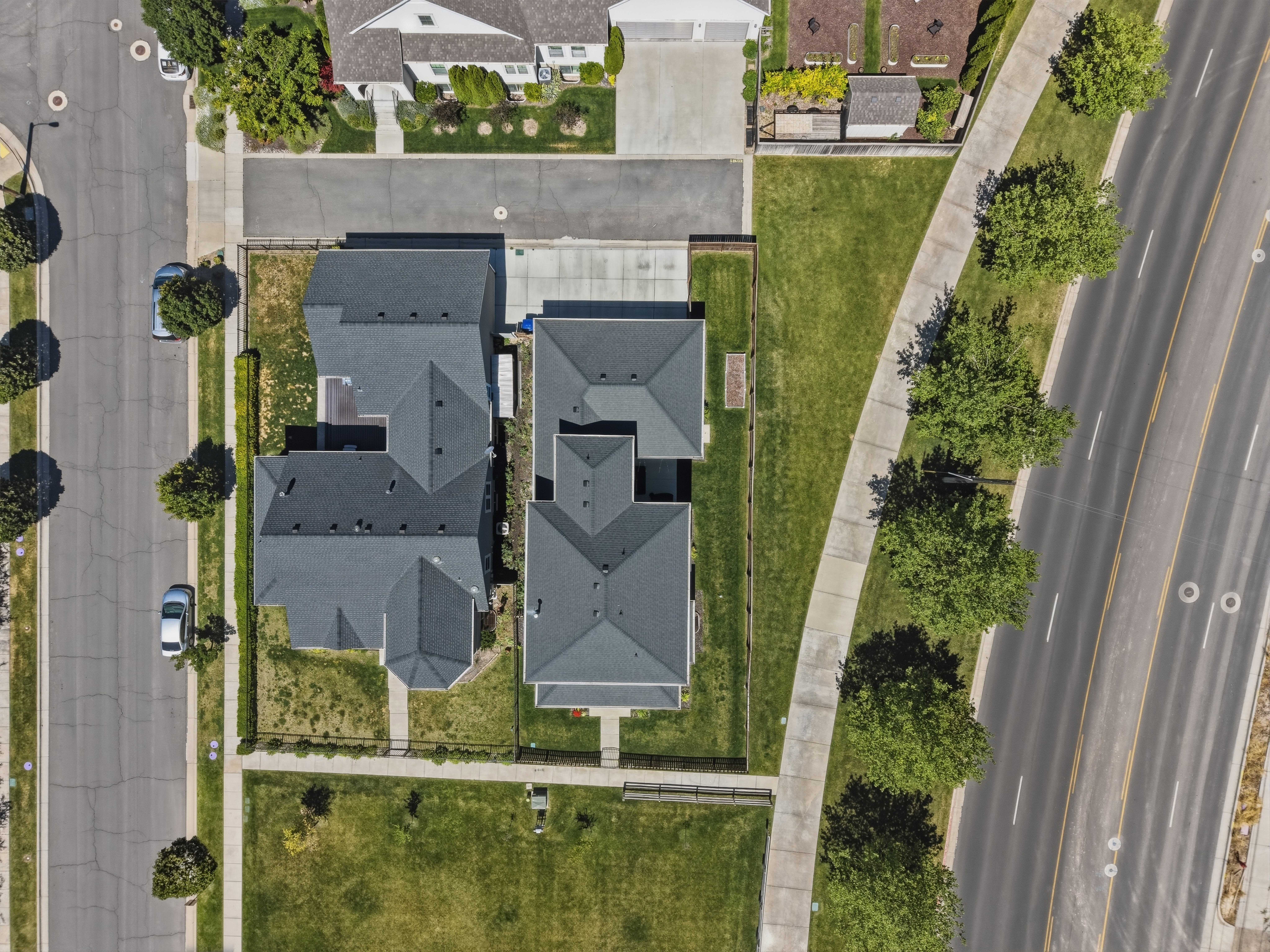 Residential property featuring dark gray roofing and a manicured lawn