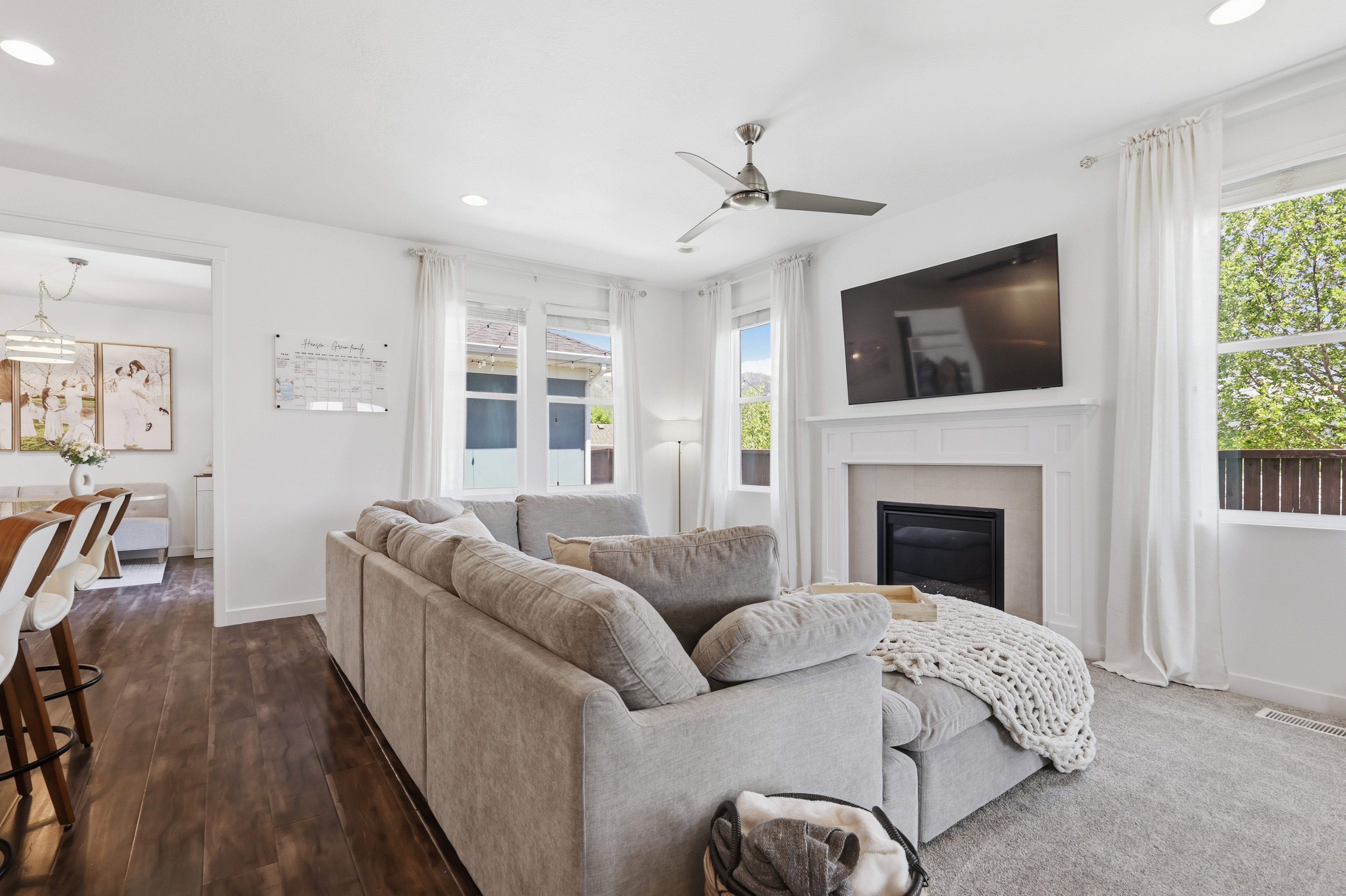Living room featuring a fireplace with a mantel, recessed lighting, and a ceiling fan