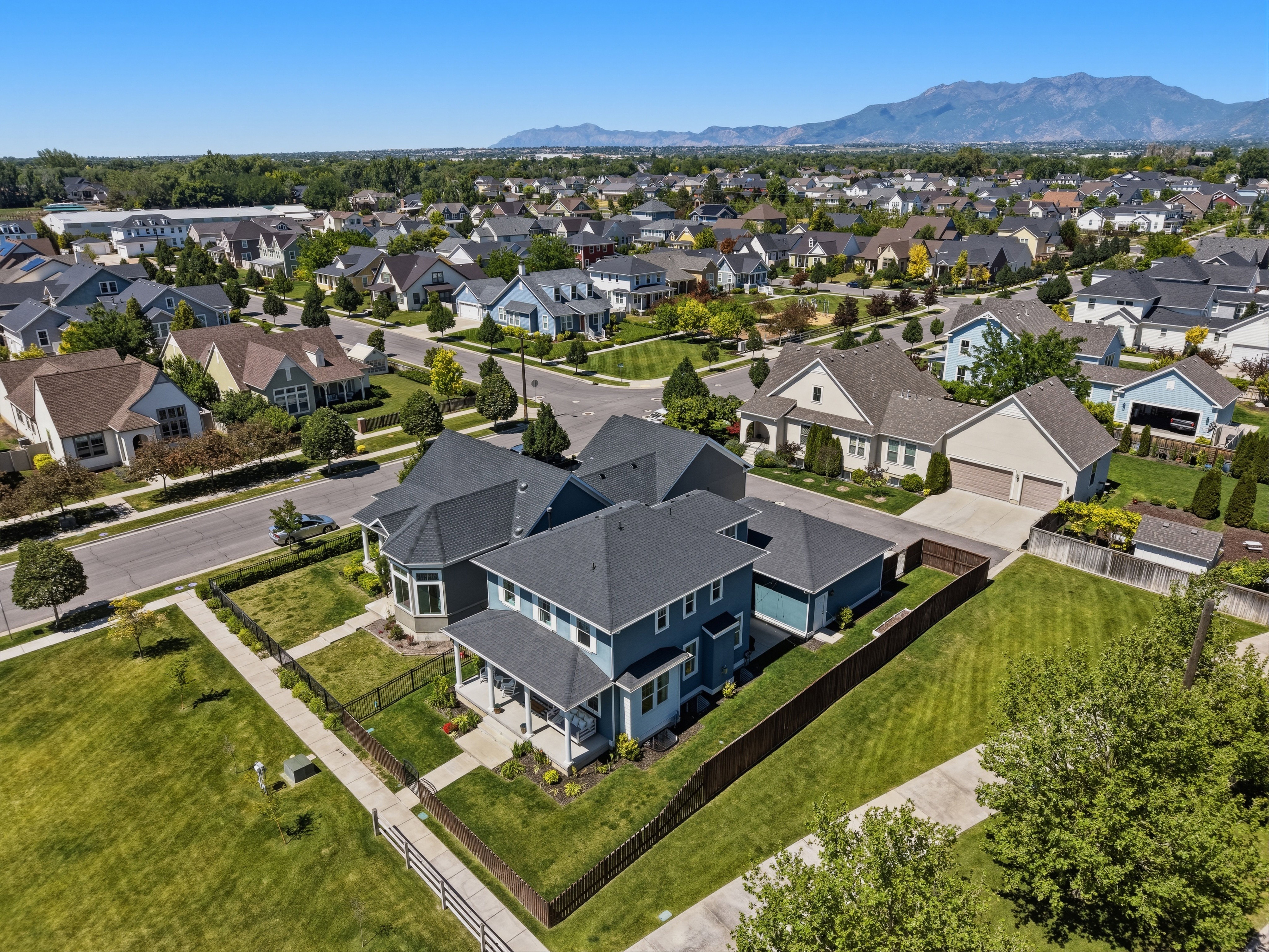 Expansive neighborhood setting with numerous residential properties, mature green landscaping, and paved streets
