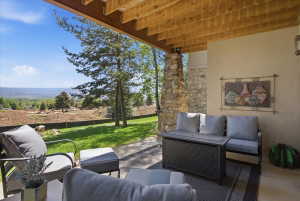 Covered patio featuring views of the golf course and a gas fire pit