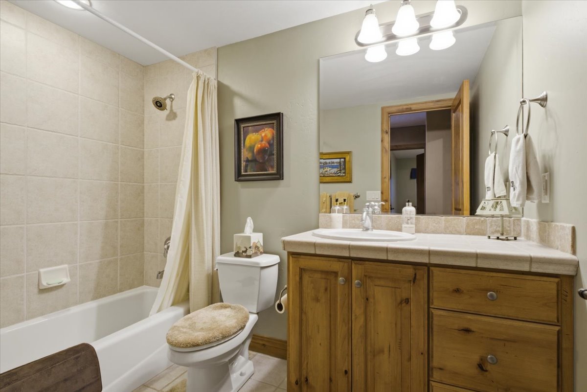 Bathroom featuring a light-toned tile shower surround with a white tub