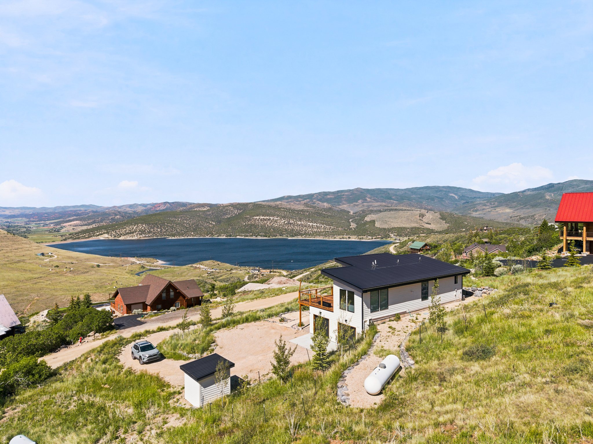Contemporary residence featuring a flat roof and a wooden deck