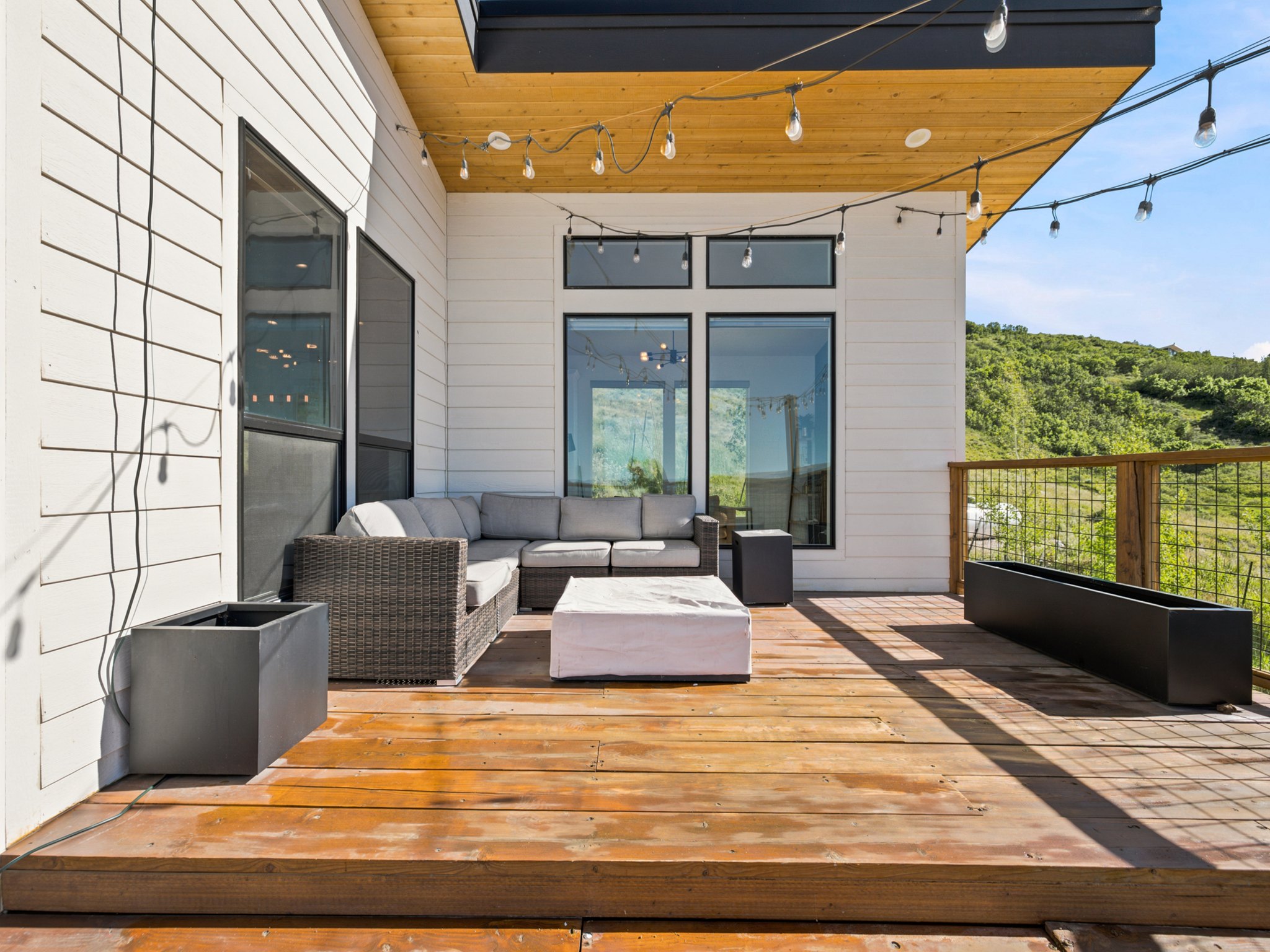 Expansive wood-finish deck with a wood plank ceiling and black trim