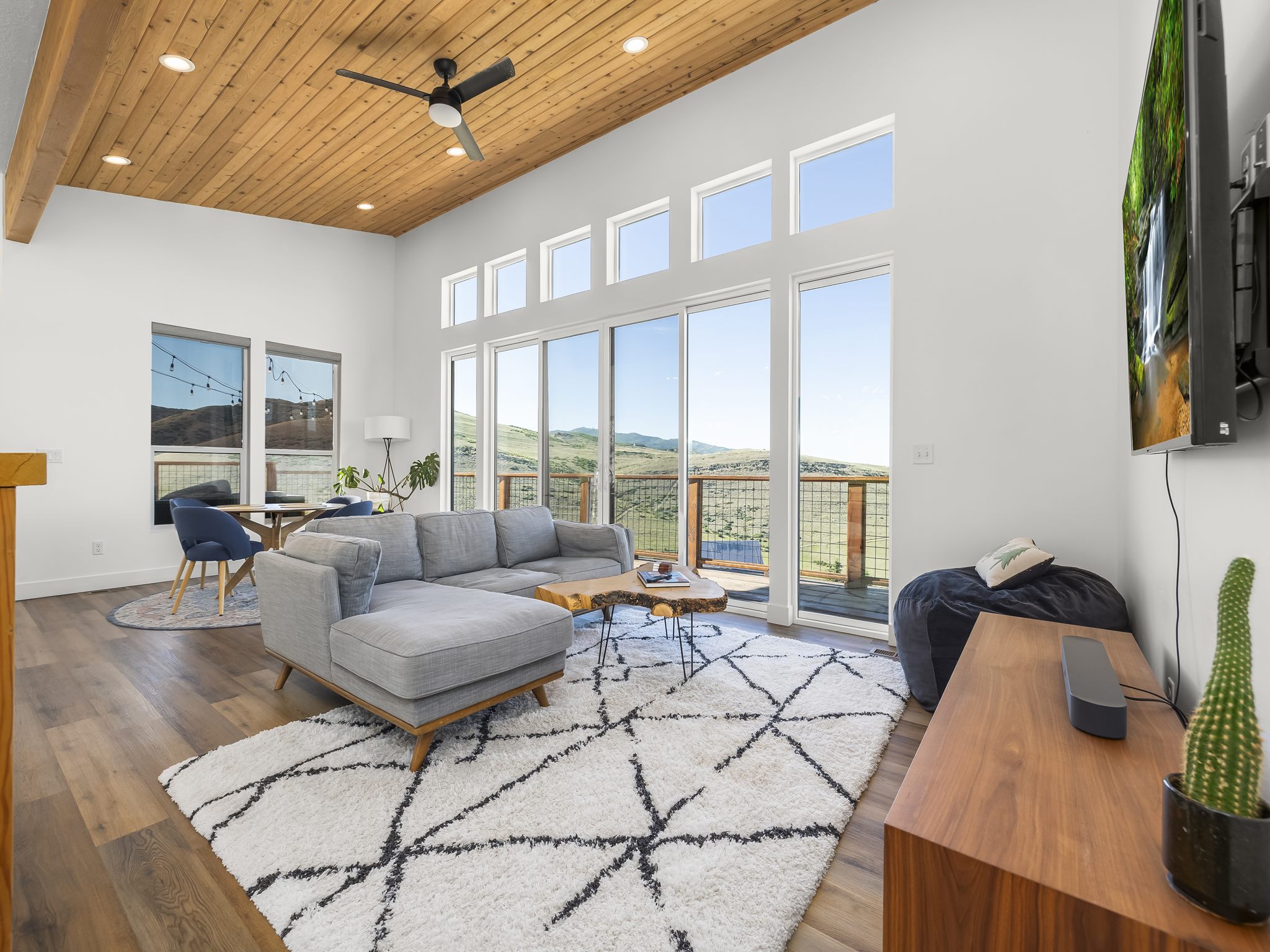 Spacious living area featuring a vaulted wood-paneled ceiling, exposed wood beam, recessed lighting, and a ceiling fan