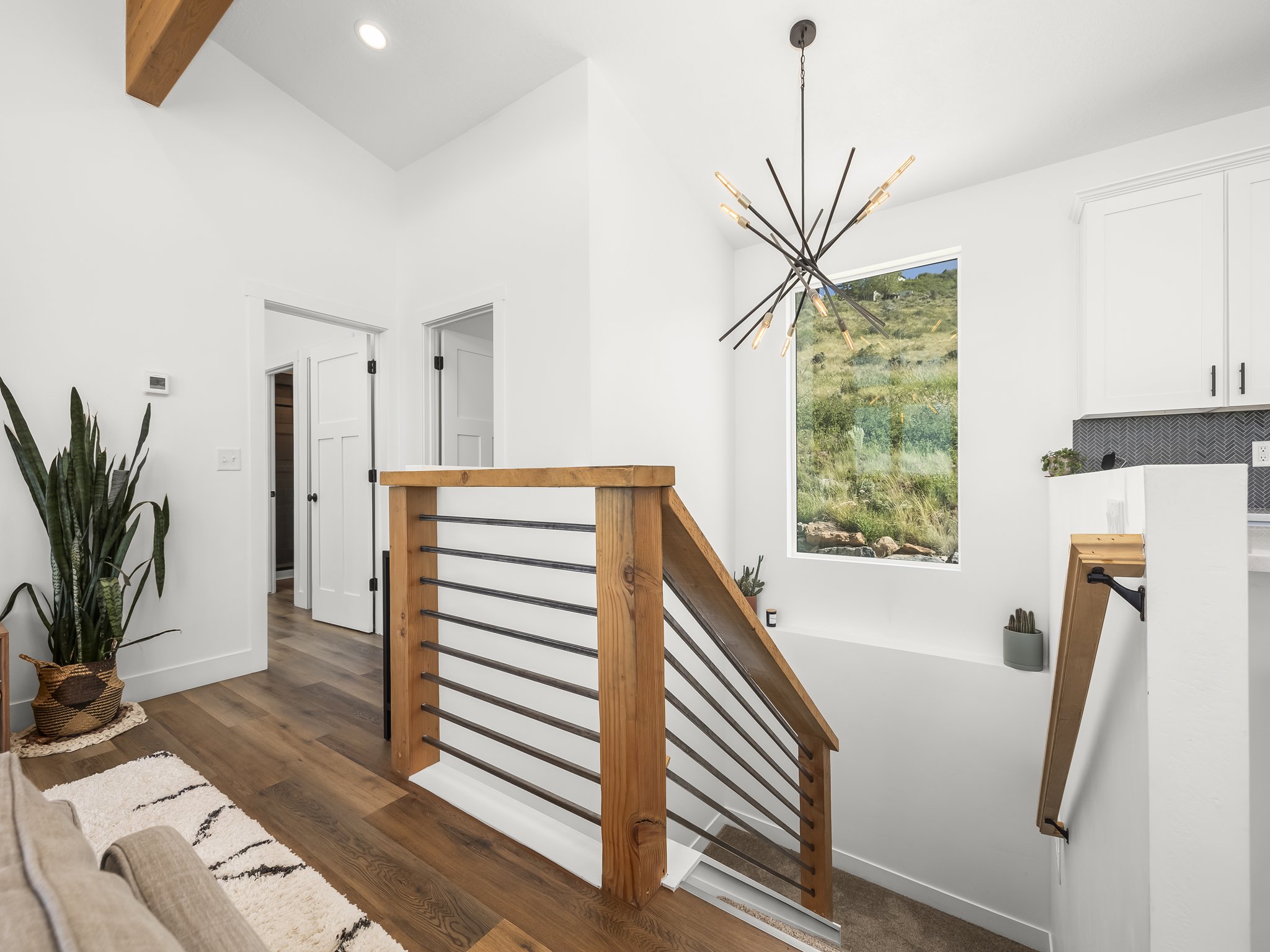 Modern staircase featuring wood-finish railings with metal balusters