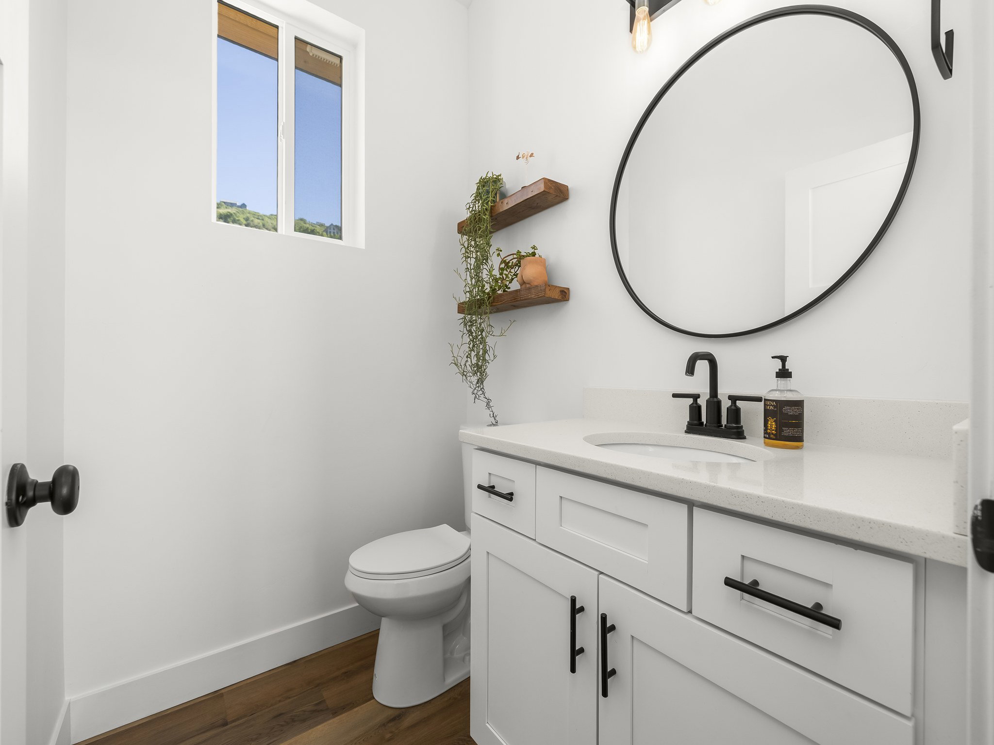 Modern bathroom featuring a white vanity with shaker-style cabinetry, a built-in sink, and a light-toned countertop