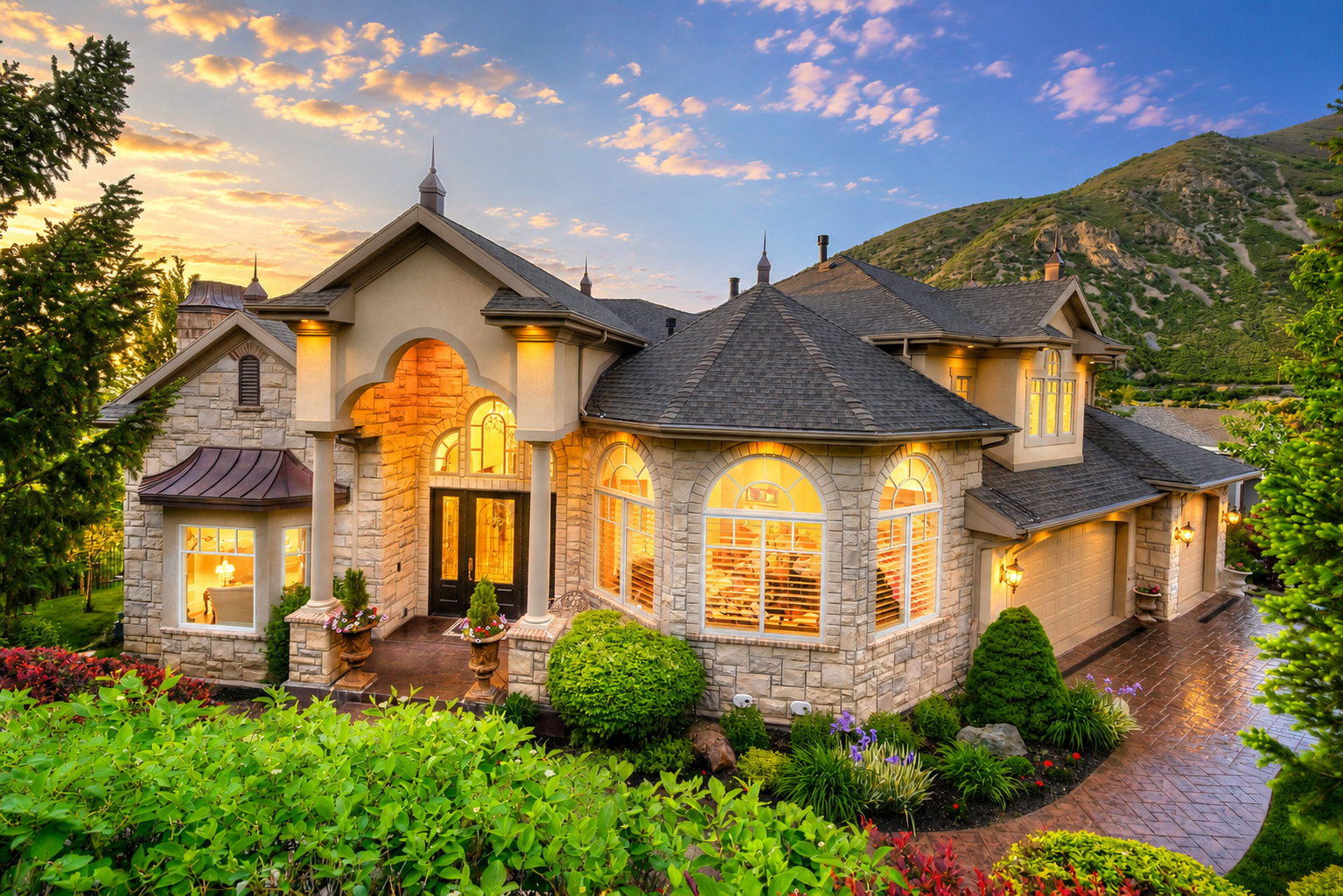 Stone facade residence featuring multiple dormers, arched entryway, and bay windows