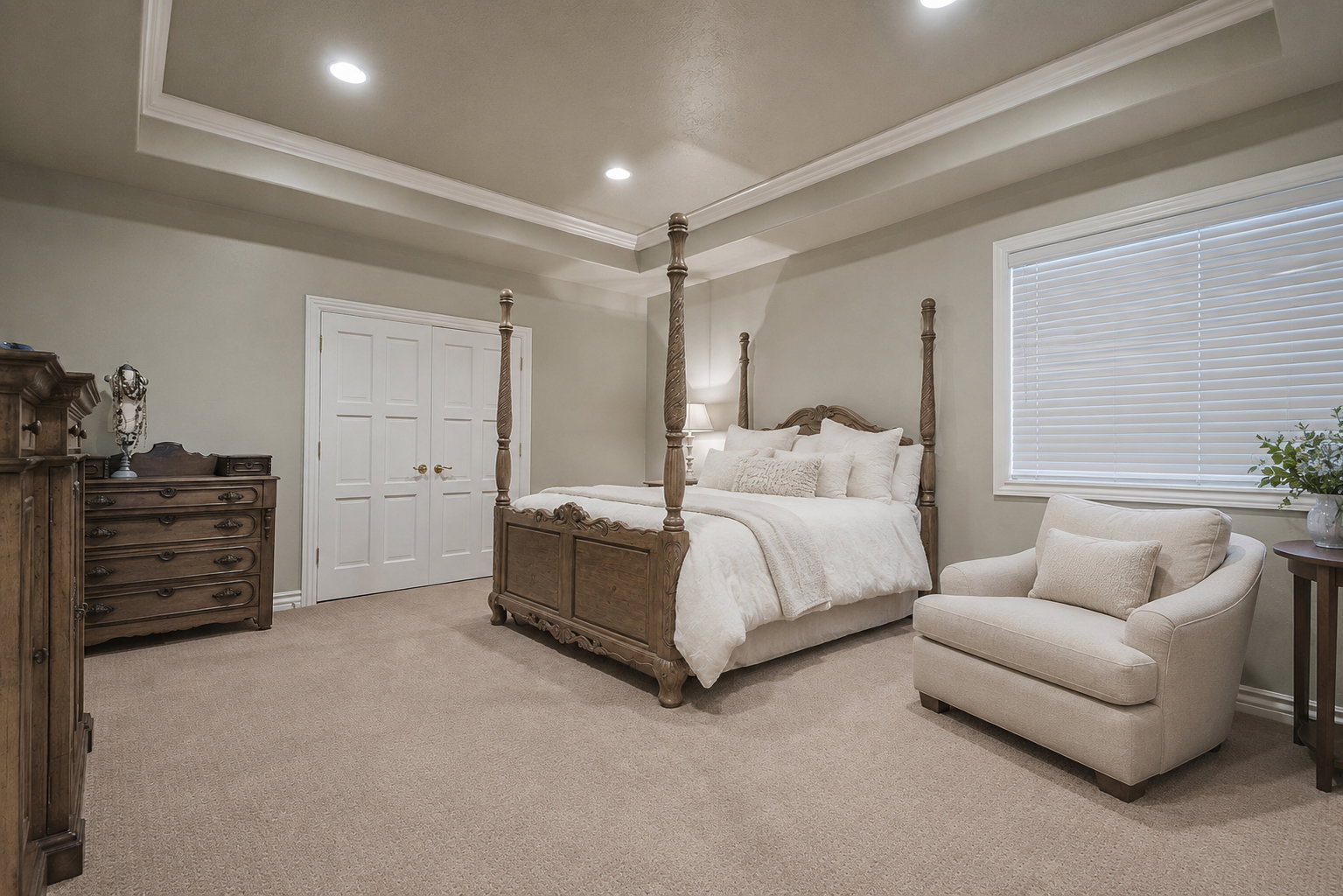 Spacious room featuring tray ceilings with recessed lighting, neutral-toned carpeting, a large window with blinds, and white double-panel doors