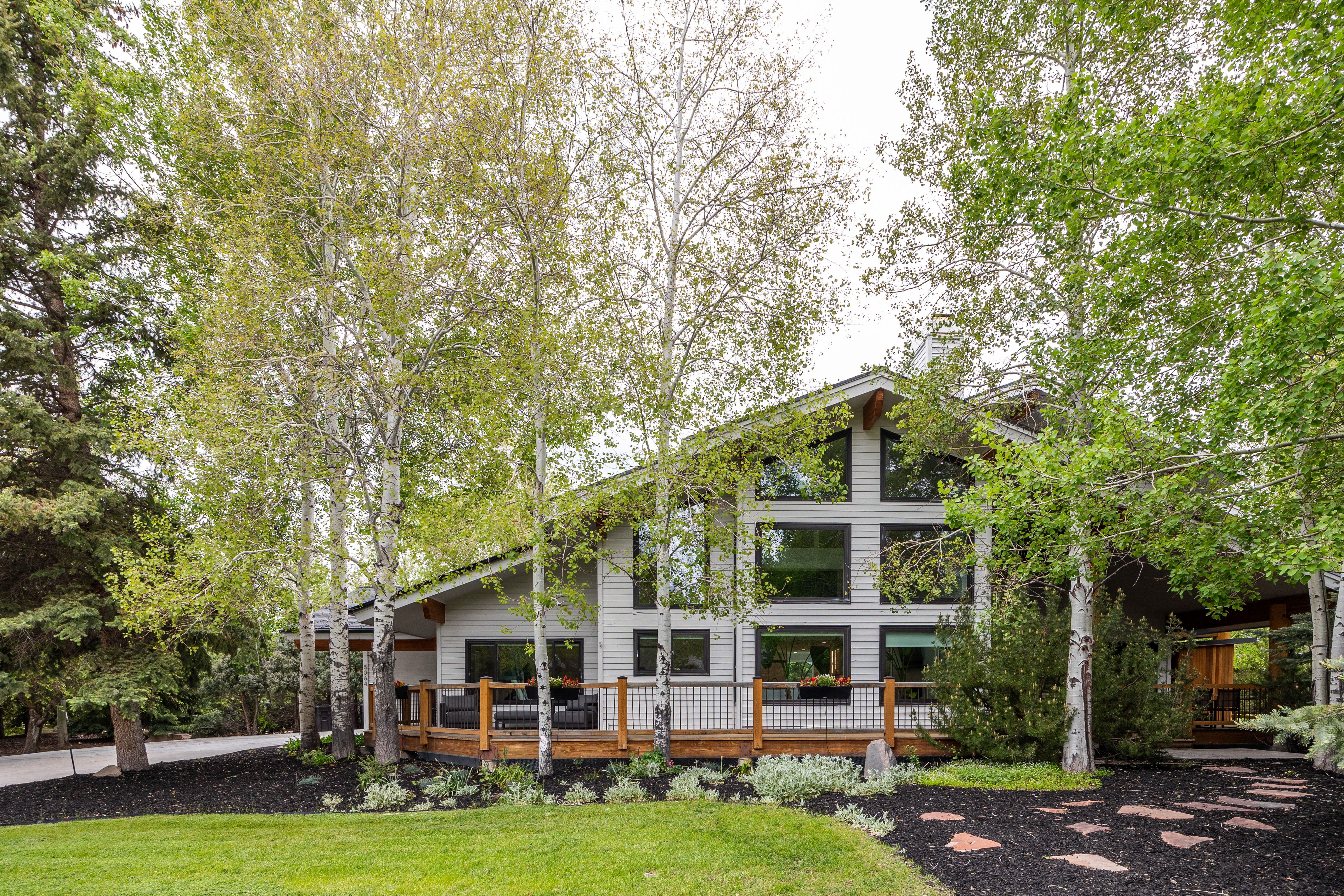 Contemporary-style residence featuring a prominent gabled roofline and light-colored siding
