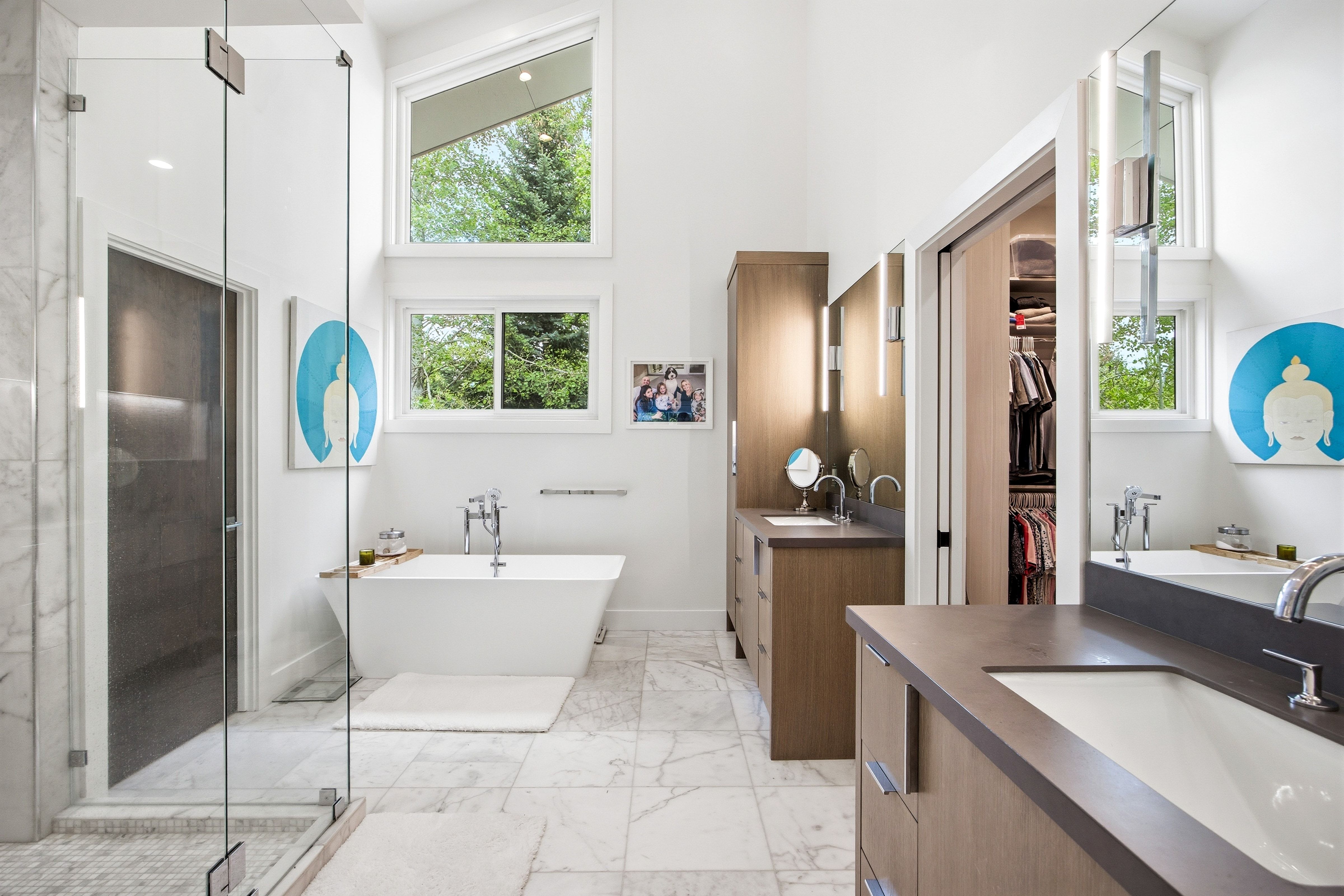 Spacious bathroom featuring a freestanding soaking tub, dual vanity with undermount sinks, and a glass-enclosed shower