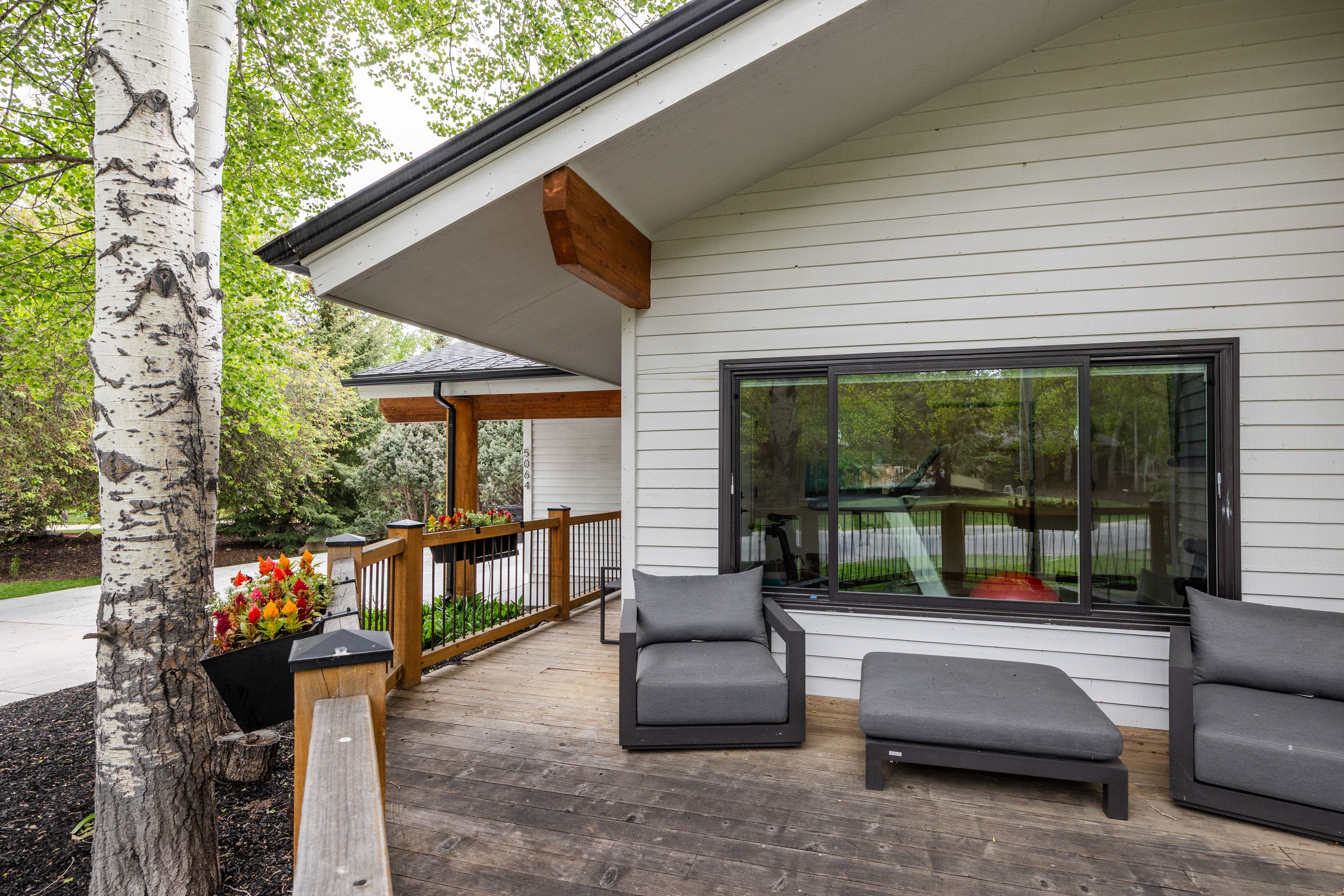 Expansive outdoor deck featuring wood-finish flooring and a wood railing with black spindles
