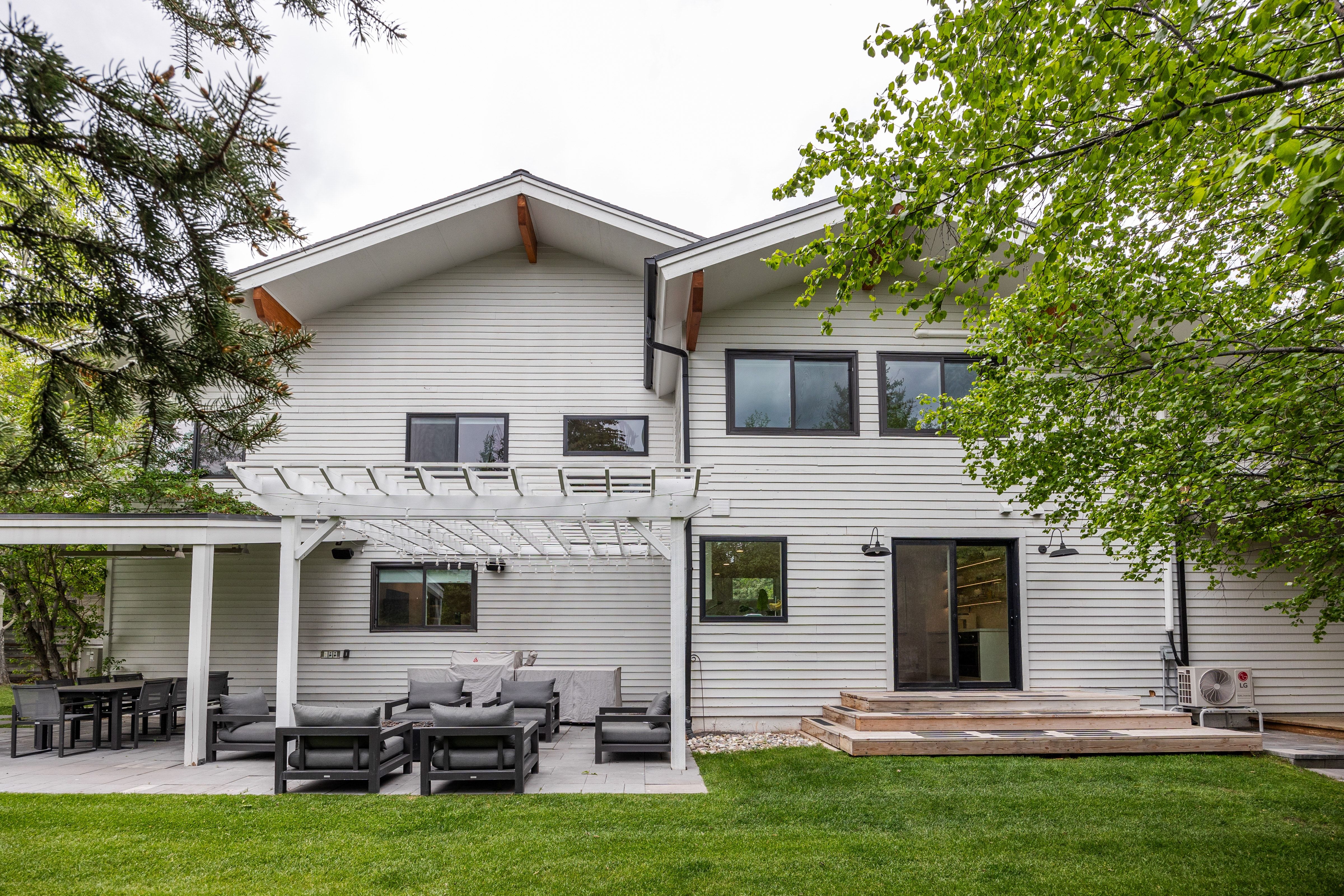 Modern exterior featuring light-colored horizontal siding and a gabled roofline with exposed wood architectural elements