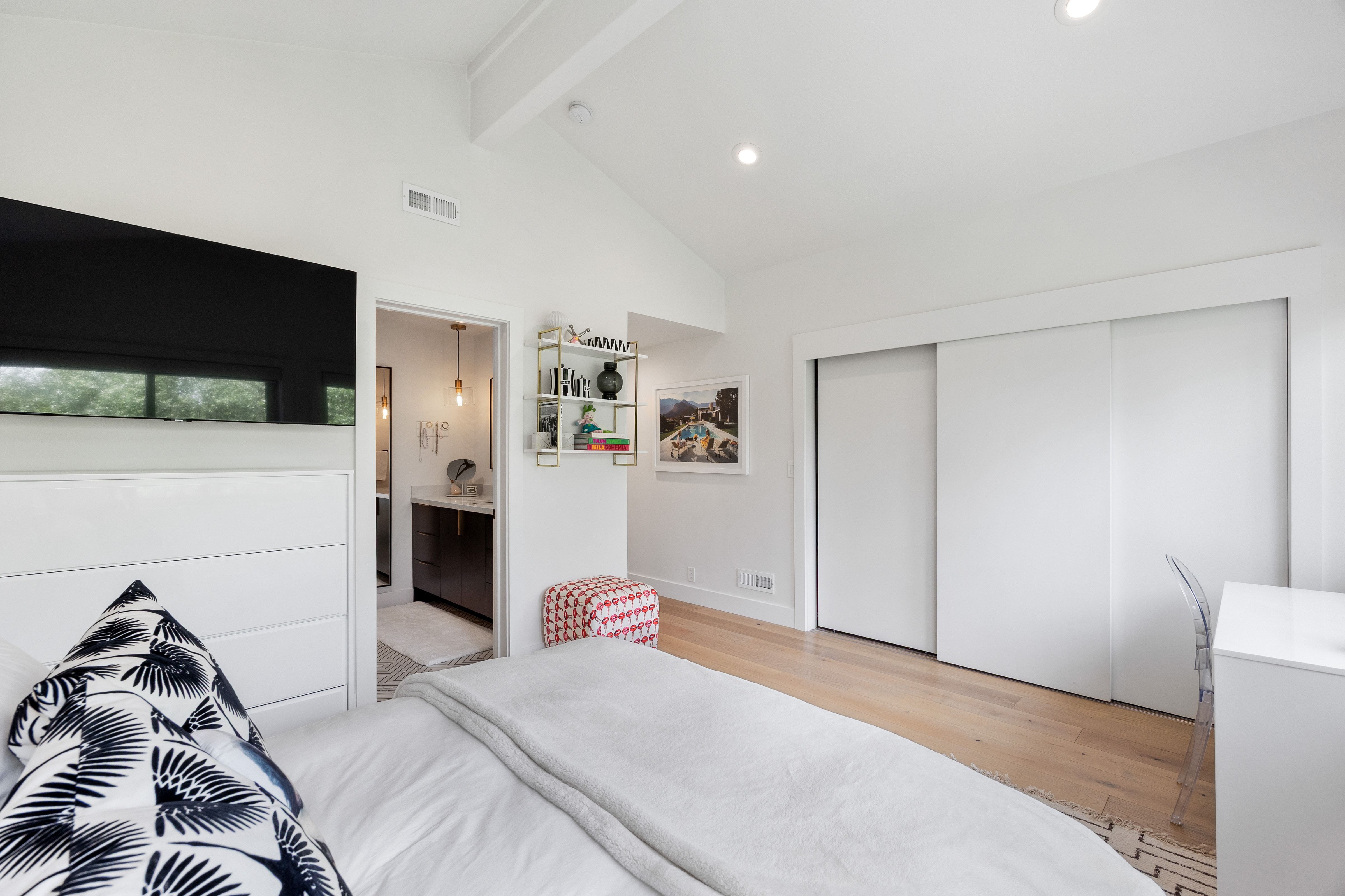 Bedroom featuring vaulted ceilings with exposed beam, light wood-finish flooring, recessed lighting, and sliding closet doors