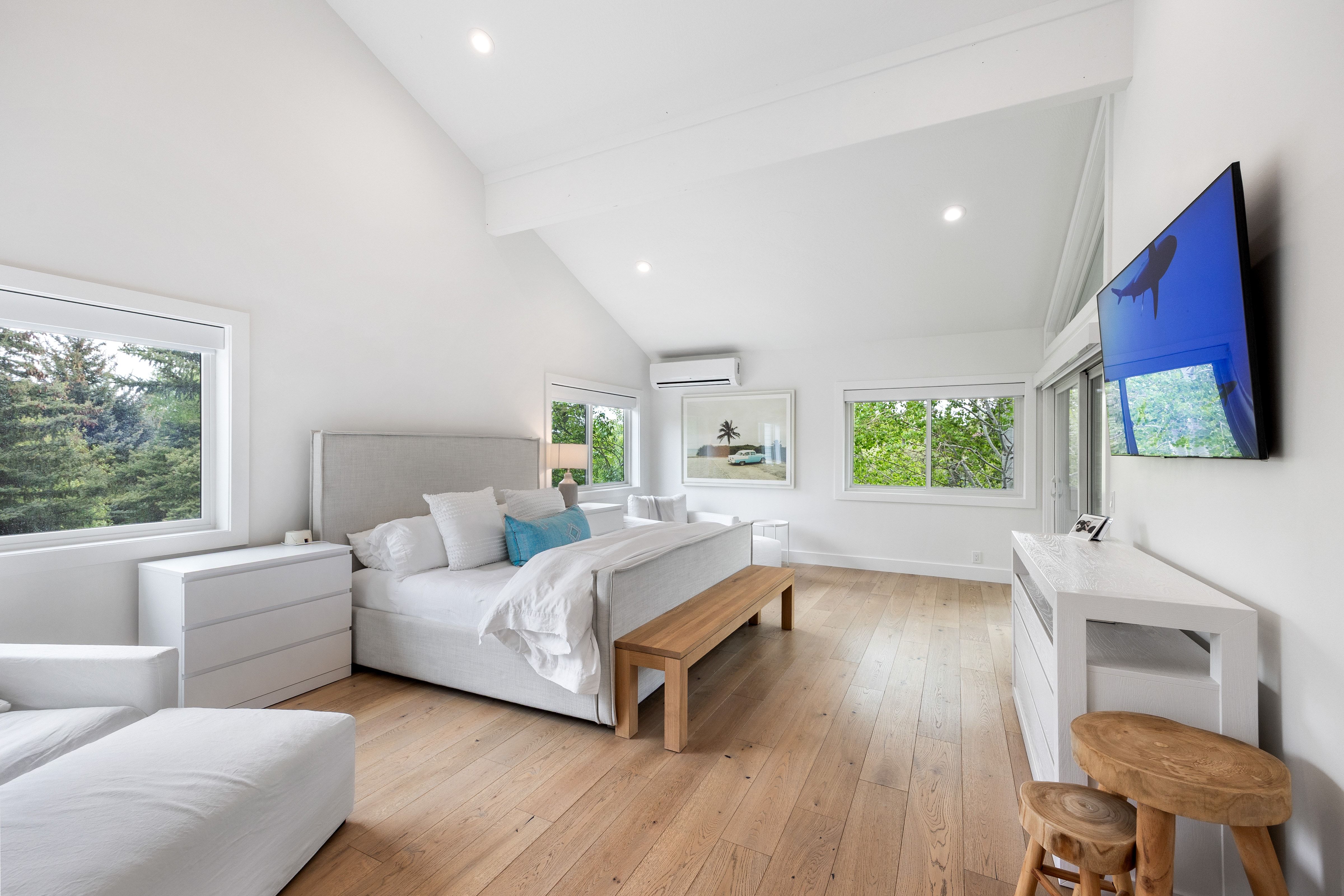 Vaulted ceilings with exposed beams complement the light wood-finish flooring