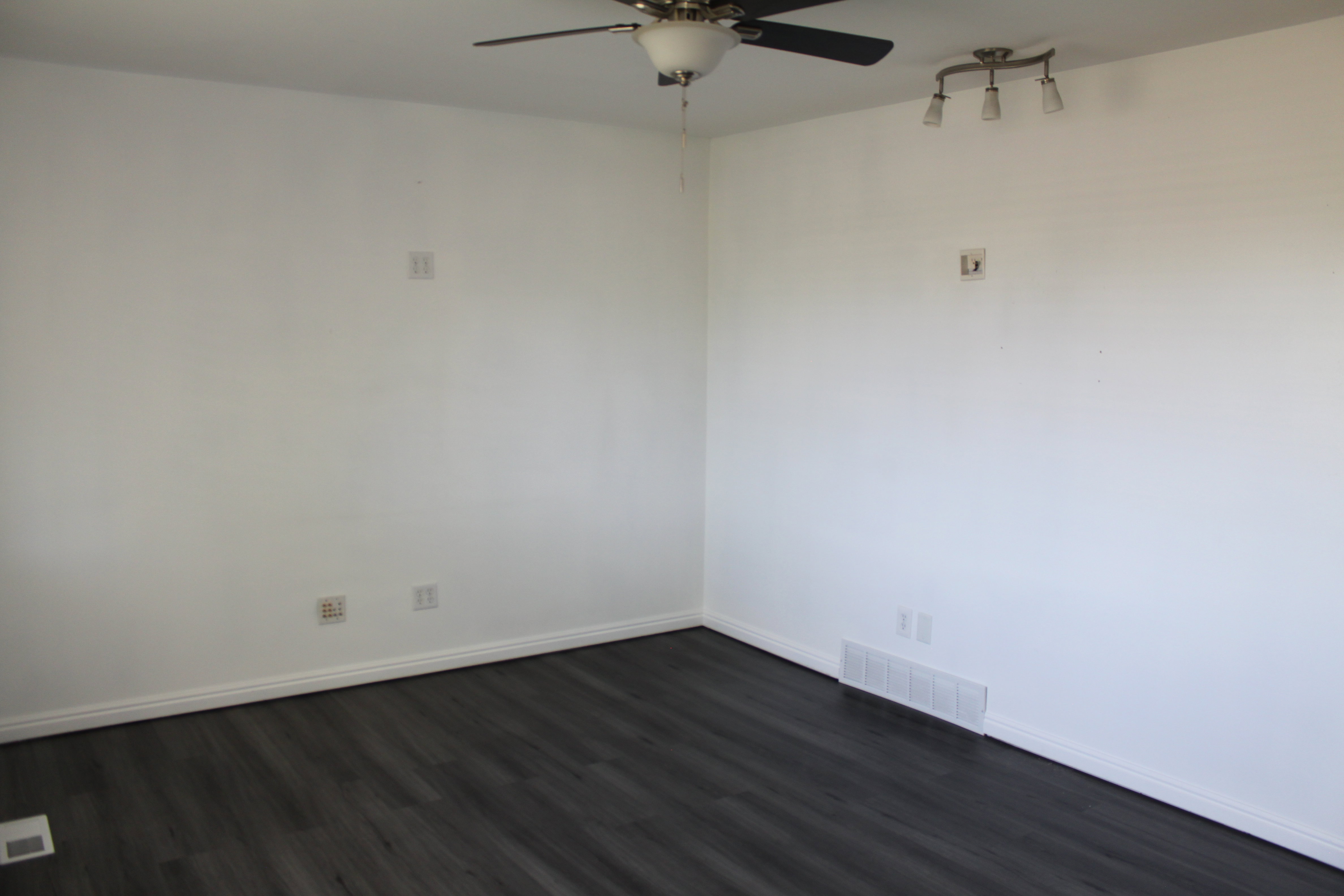 Dark wood-finish flooring with white baseboards