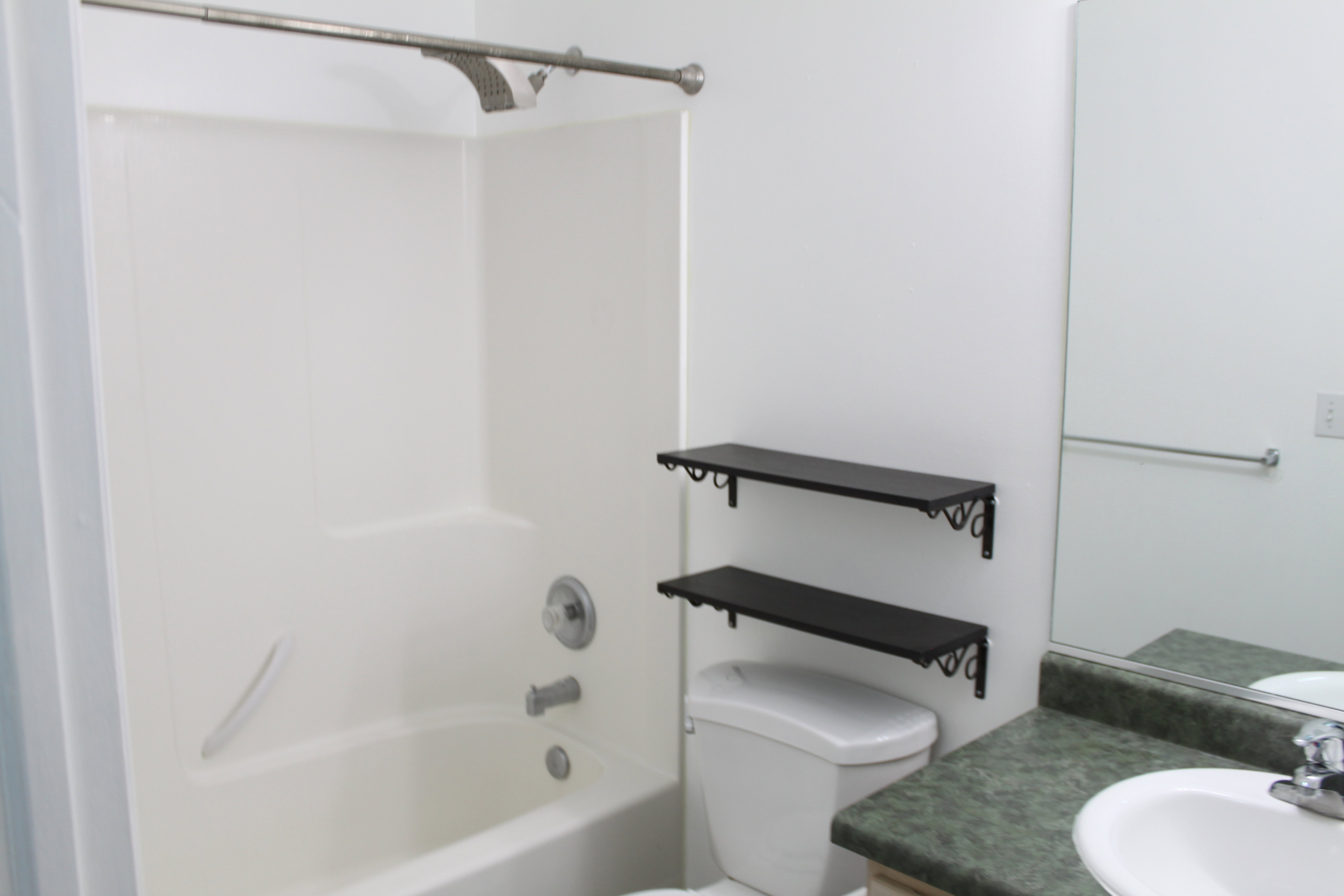 Full-size bathtub with integrated shower, chrome fixtures, and white surround