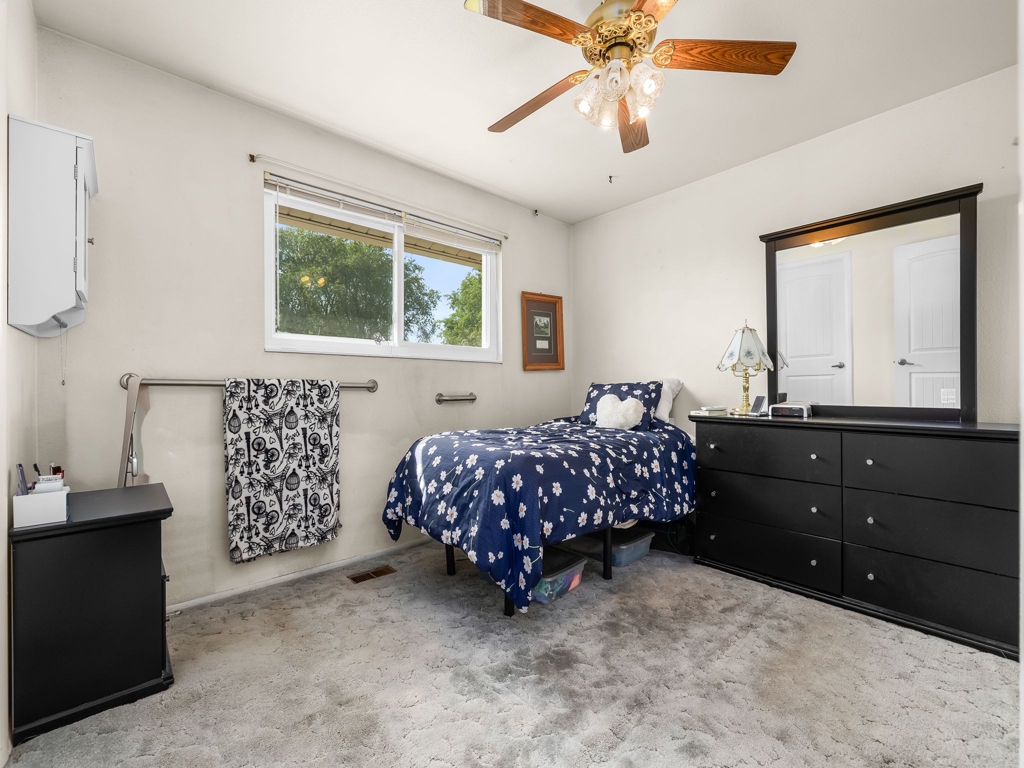 Room featuring a window, built-in ceiling fan with lighting, wall-to-wall carpeting, and light-toned wall finishes
