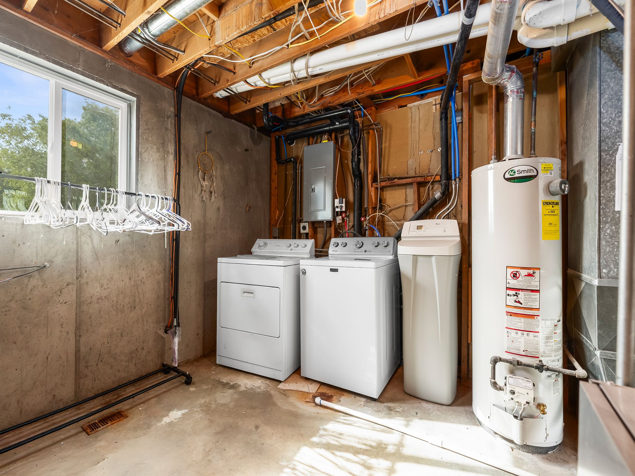 Dedicated utility area featuring a washer, dryer, water softener, and water heater