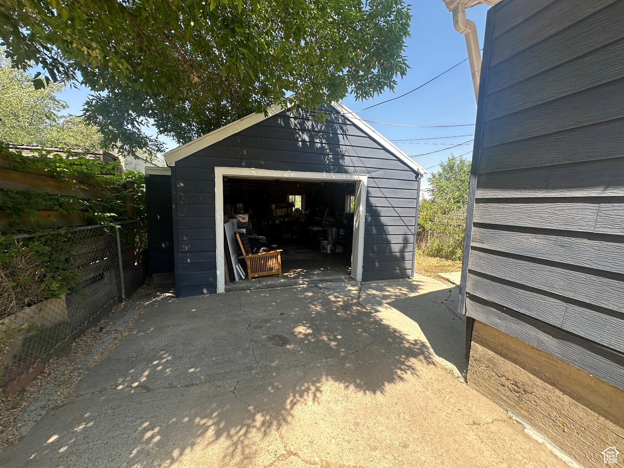 Detached garage with dark siding and white trim