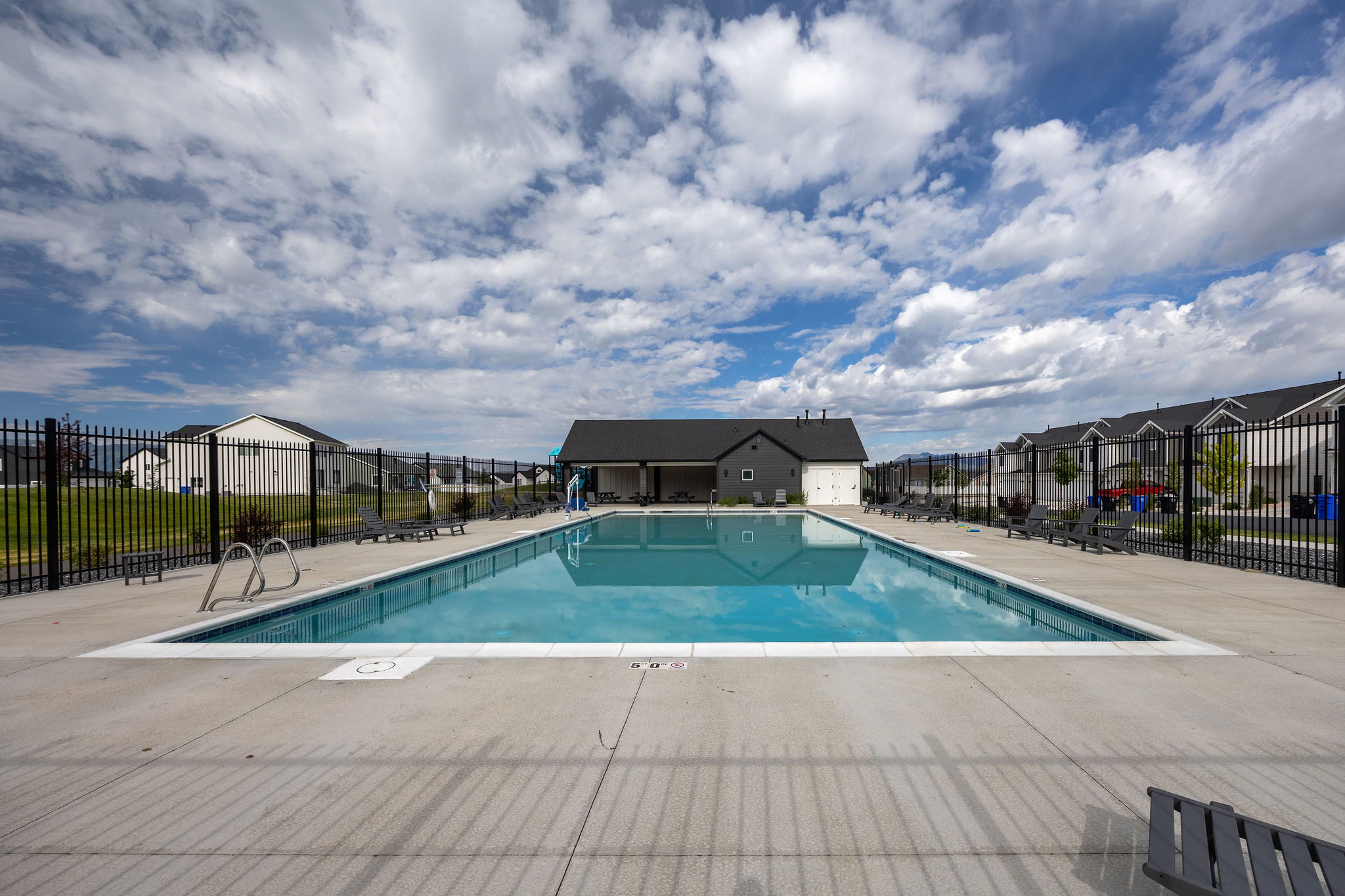 Rectangular outdoor swimming pool with concrete surround