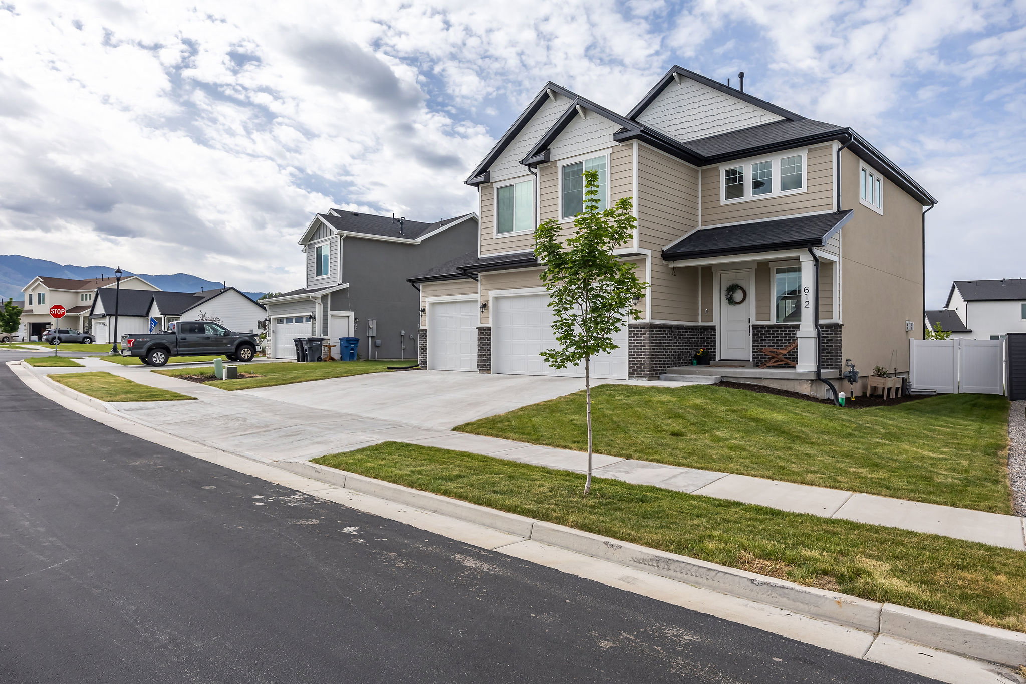 Contemporary two-story residence featuring light siding with white trim accents and a dark roof