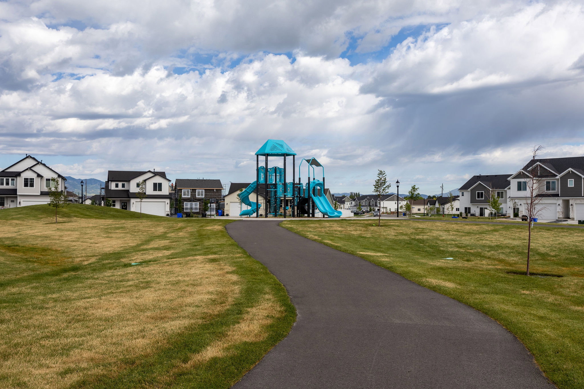 Community playground equipment featuring multiple slides, climbing structures, and elevated platforms