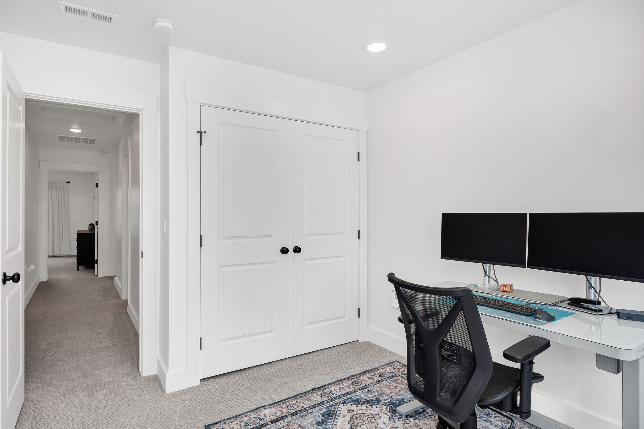 Neutral-toned room featuring a double-door closet, recessed lighting, and light gray carpet flooring