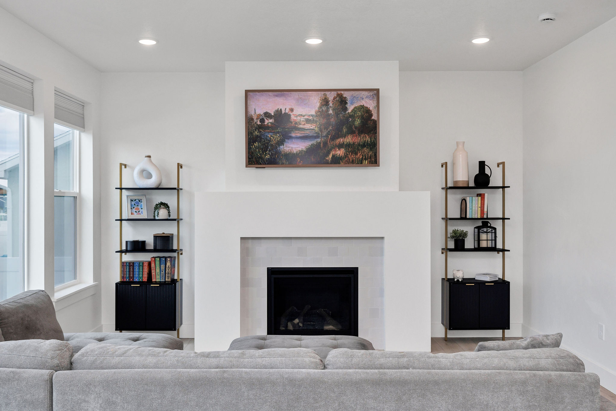 Living area featuring a floor-to-ceiling fireplace with a tiled surround, recessed lighting, and two multi-pane windows