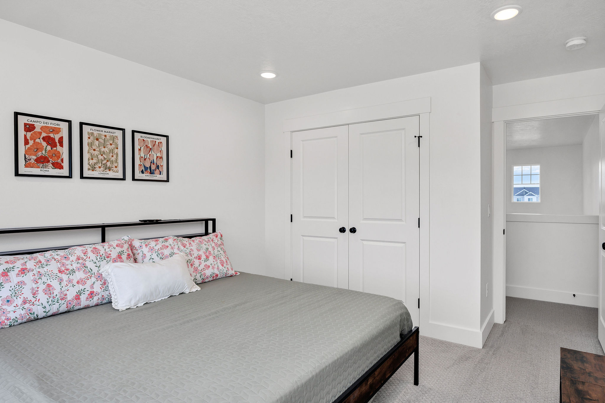 Recessed lighting illuminates this room featuring white walls and light gray carpet