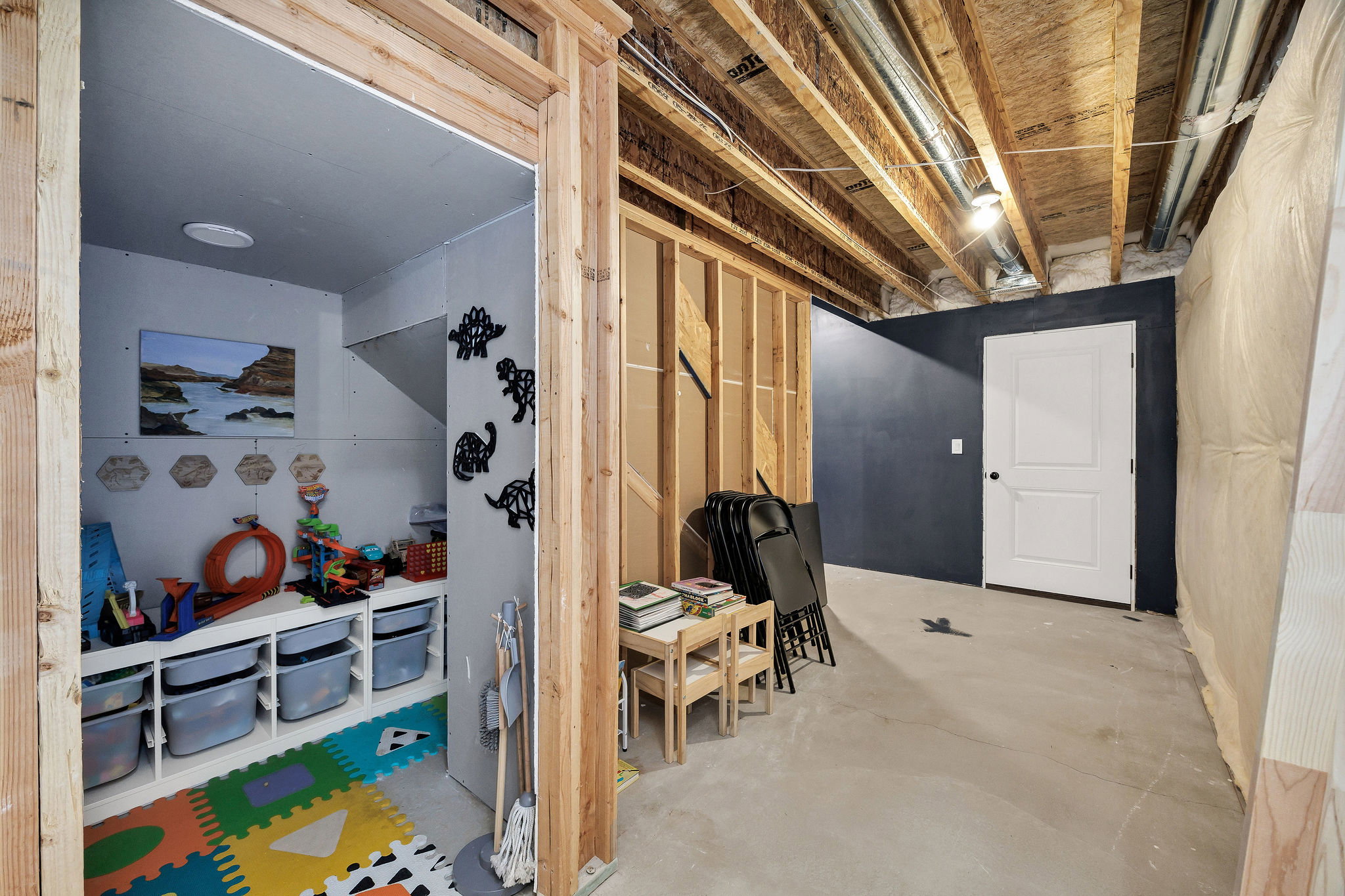 Unfinished basement featuring exposed wood joists and concrete flooring