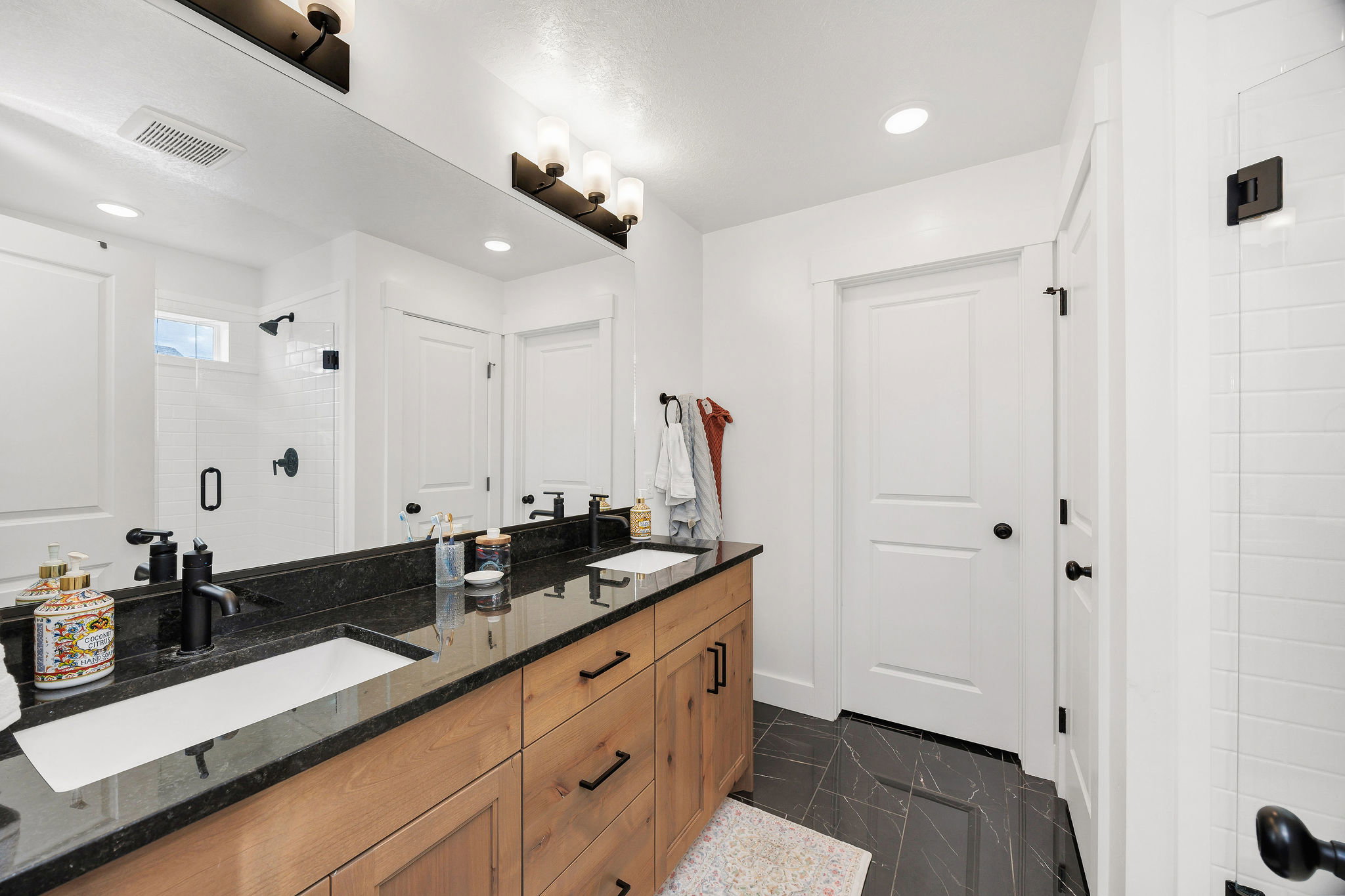 Dual vanity with dark stone countertop and integrated rectangular sinks