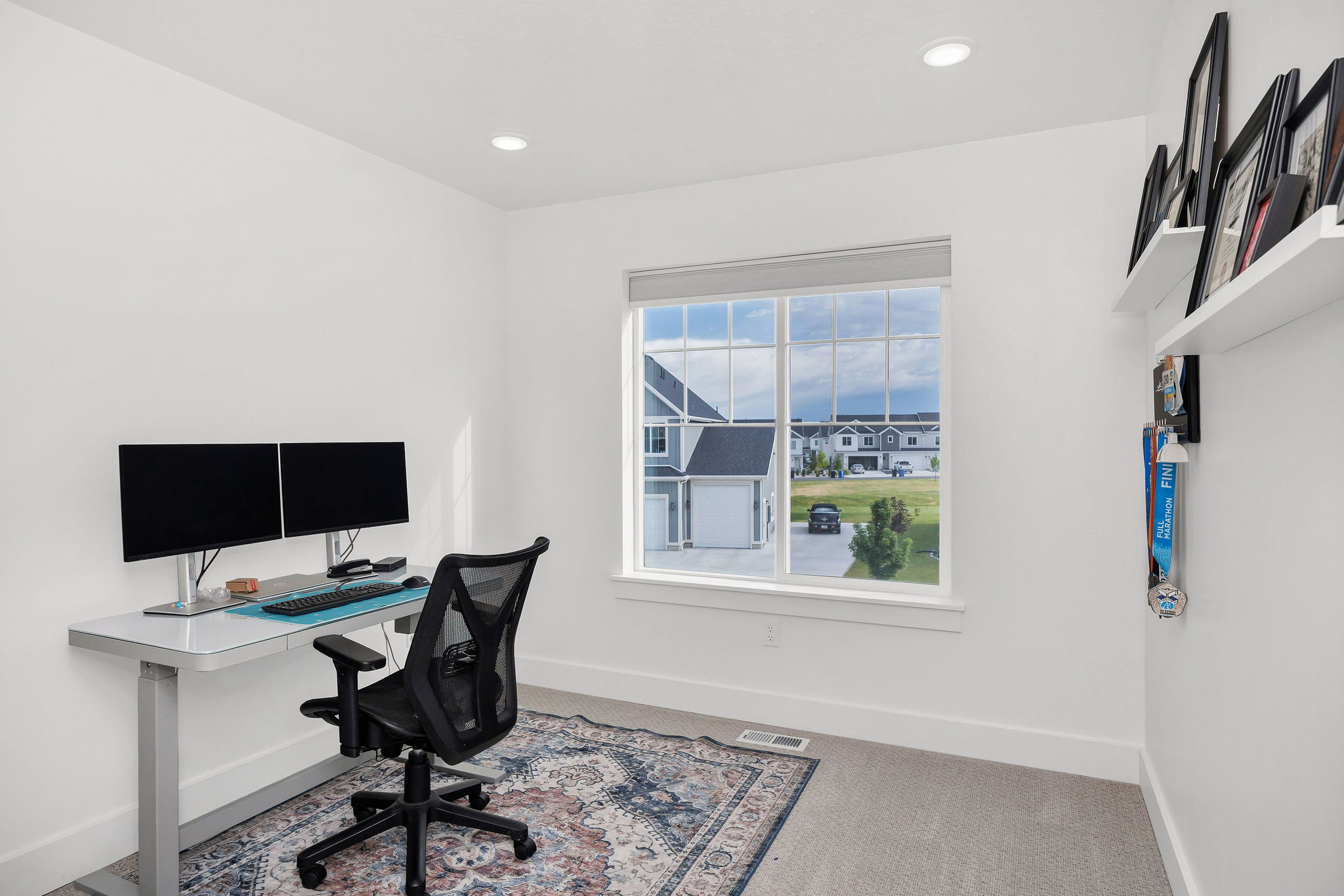 Bright room featuring a large window with grid panes, recessed ceiling lighting, and neutral wall tones
