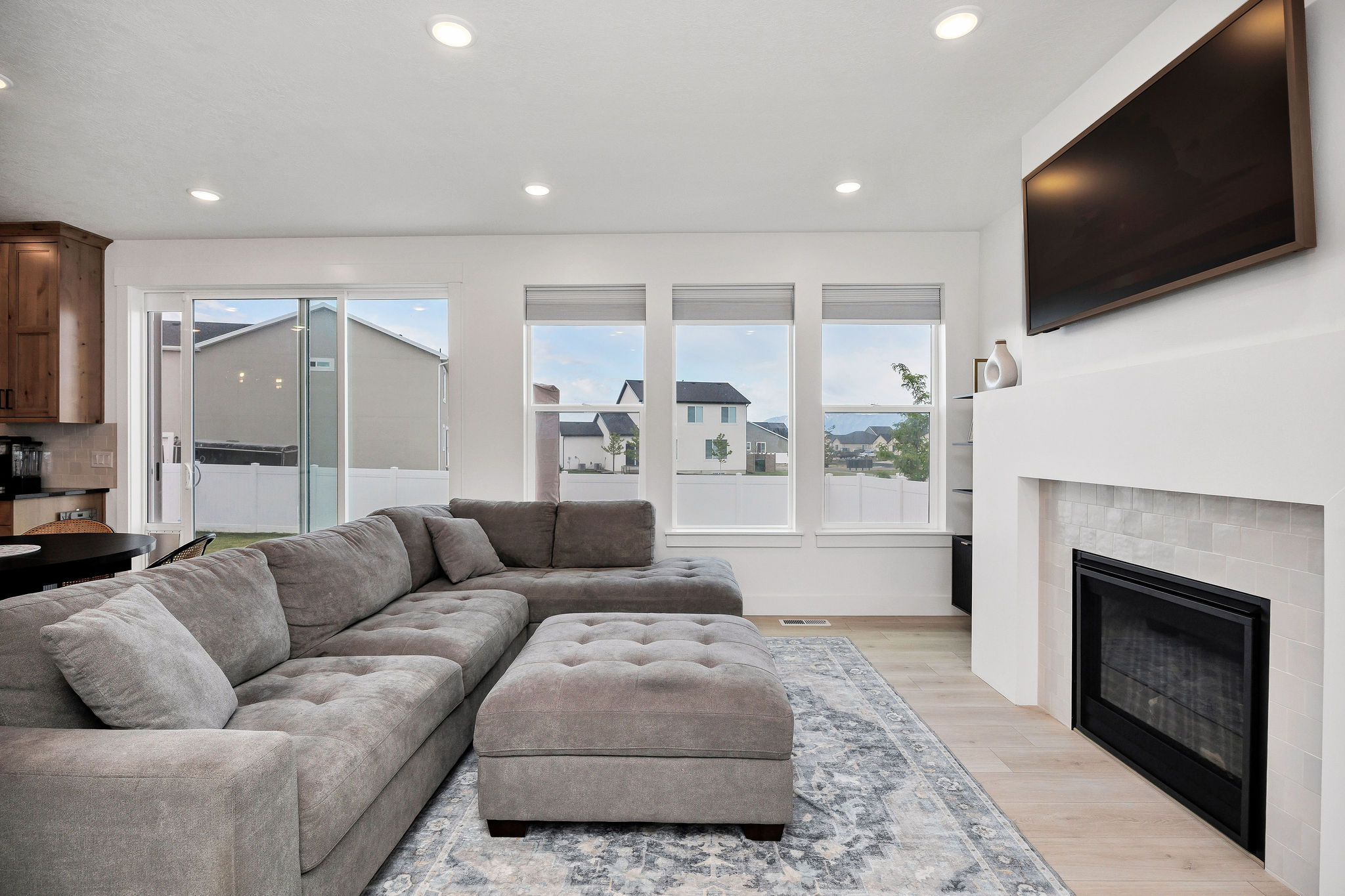Living area featuring a contemporary fireplace with a tiled surround, recessed lighting, and multiple windows