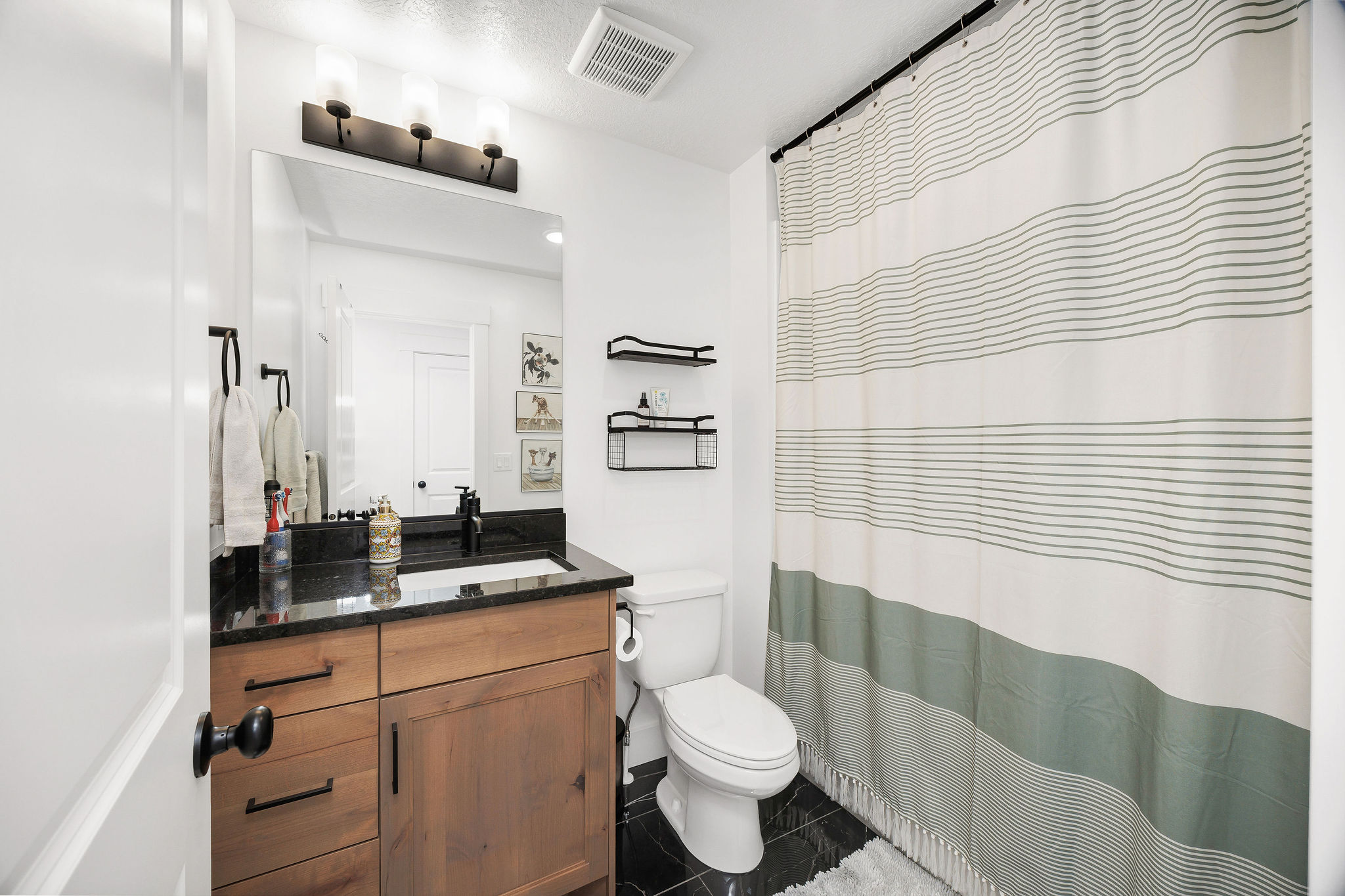 Wood-finish vanity with a dark countertop and undermount sink