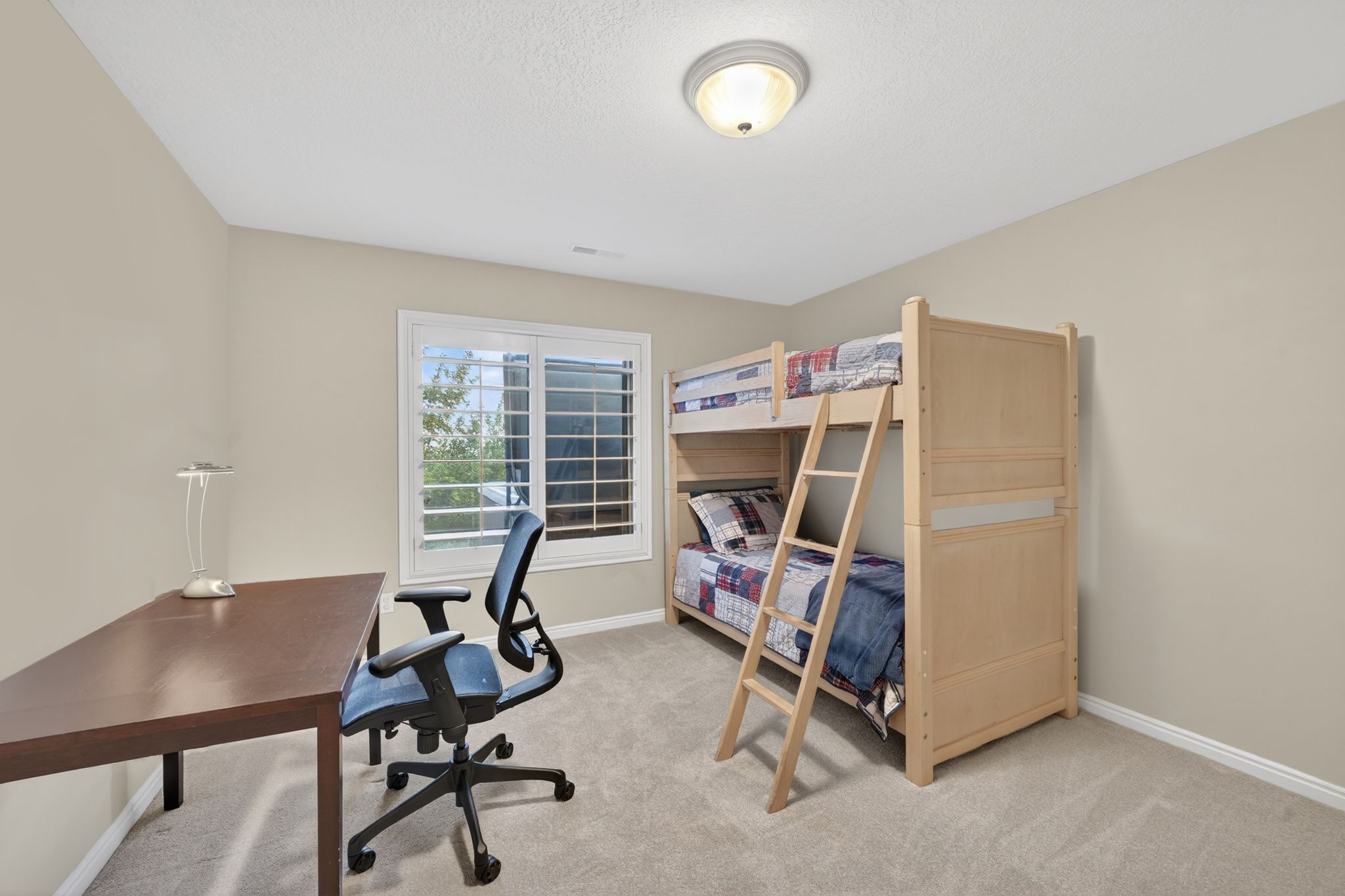 Neutral-toned room featuring a large window with white plantation shutters, a semi-flush mount ceiling light, and light-colored carpeting