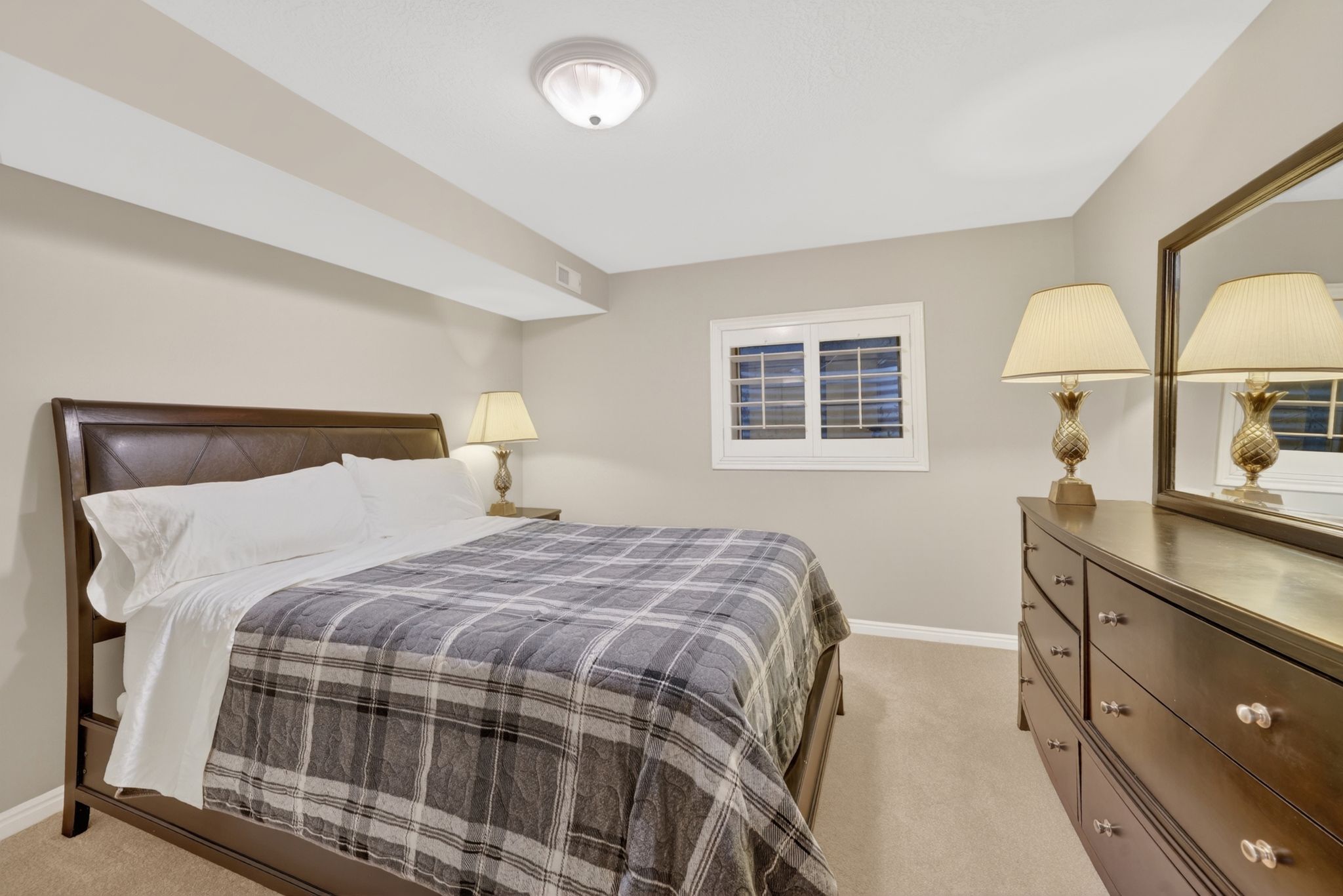 Carpeted room with neutral wall color and ceiling light fixture