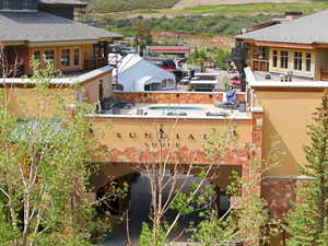 Lodge exterior featuring varied stone and stucco finishes, an arched entryway, and a rooftop spa