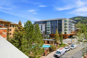 Modern multi-story building featuring contemporary architecture, multiple balconies, and a neutral color palette