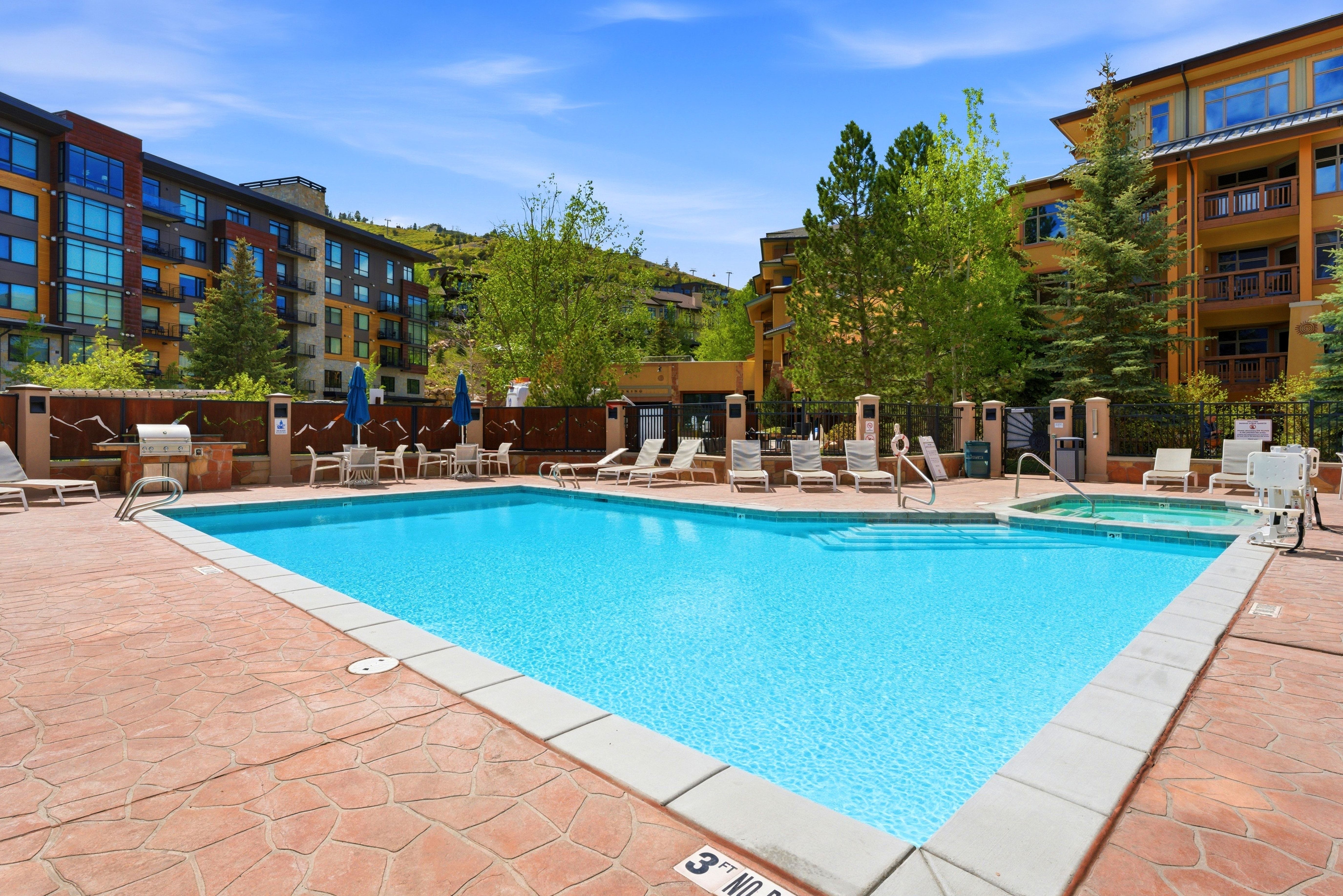 Outdoor swimming pool with integrated spa and patterned concrete decking