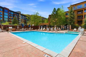 Outdoor swimming pool with integrated spa and patterned concrete decking