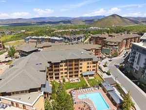 Expansive community featuring multi-story residential buildings with balconies, a central swimming pool, and a spa area