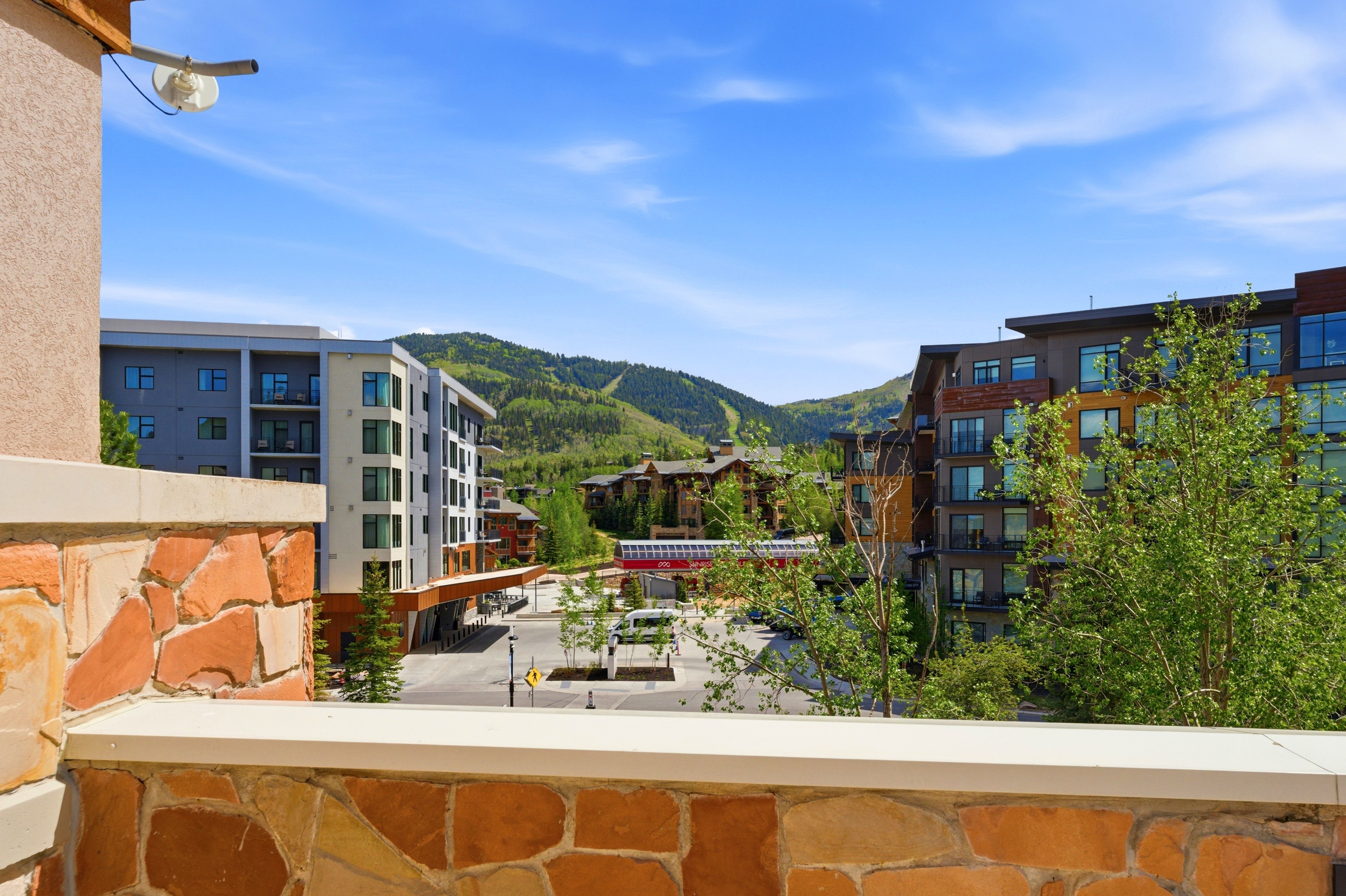 Stone-clad balcony wall with a capstone, overlooking a mountain landscape