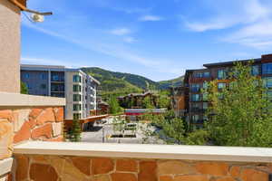 Stone-clad balcony wall with a capstone, overlooking a mountain landscape