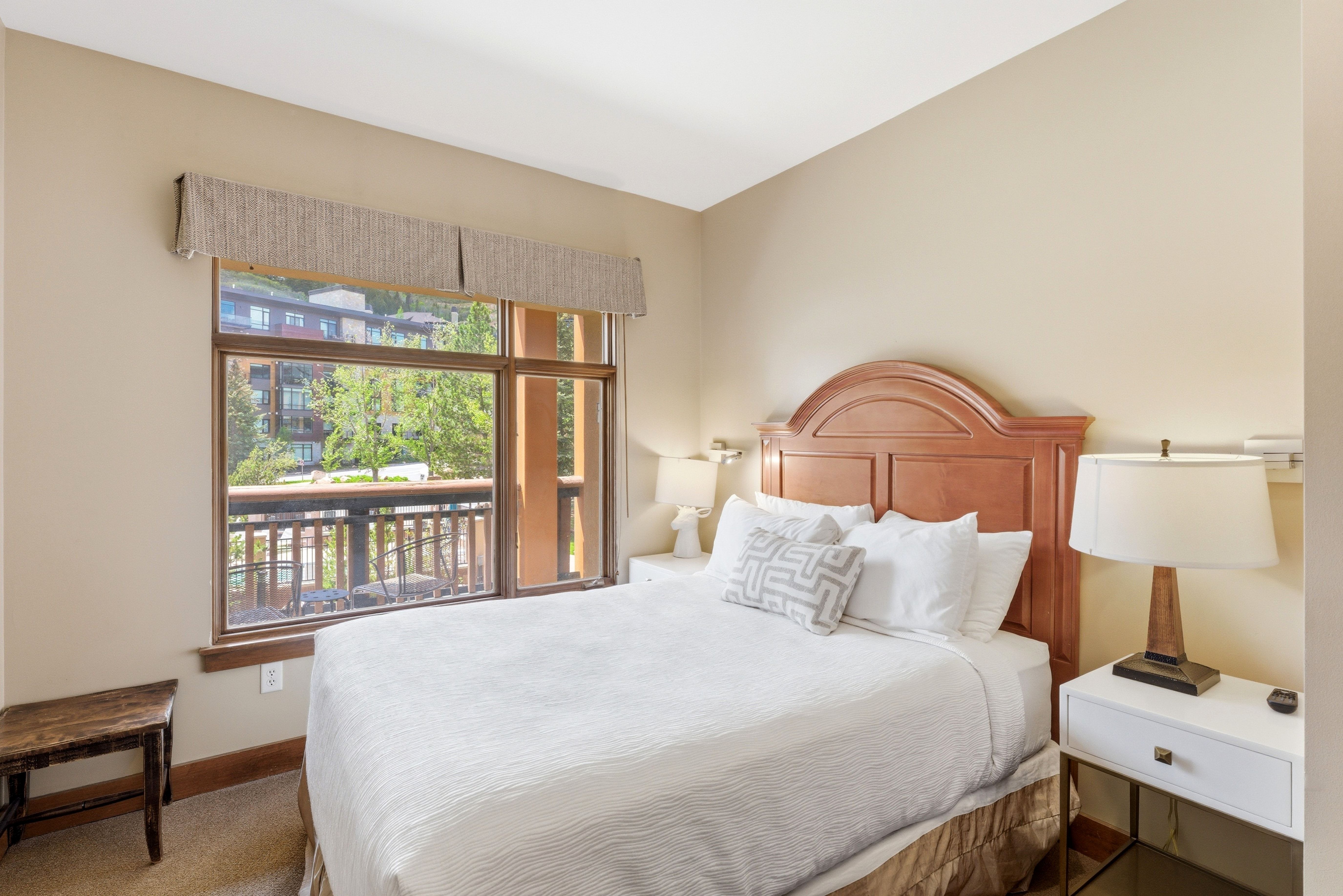 Bedroom featuring a large window with exterior balcony access
