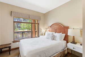 Bedroom featuring a large window with exterior balcony access