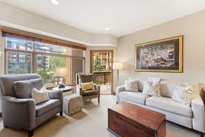 Living area featuring a wall of windows, recessed lighting, and access to an outdoor balcony